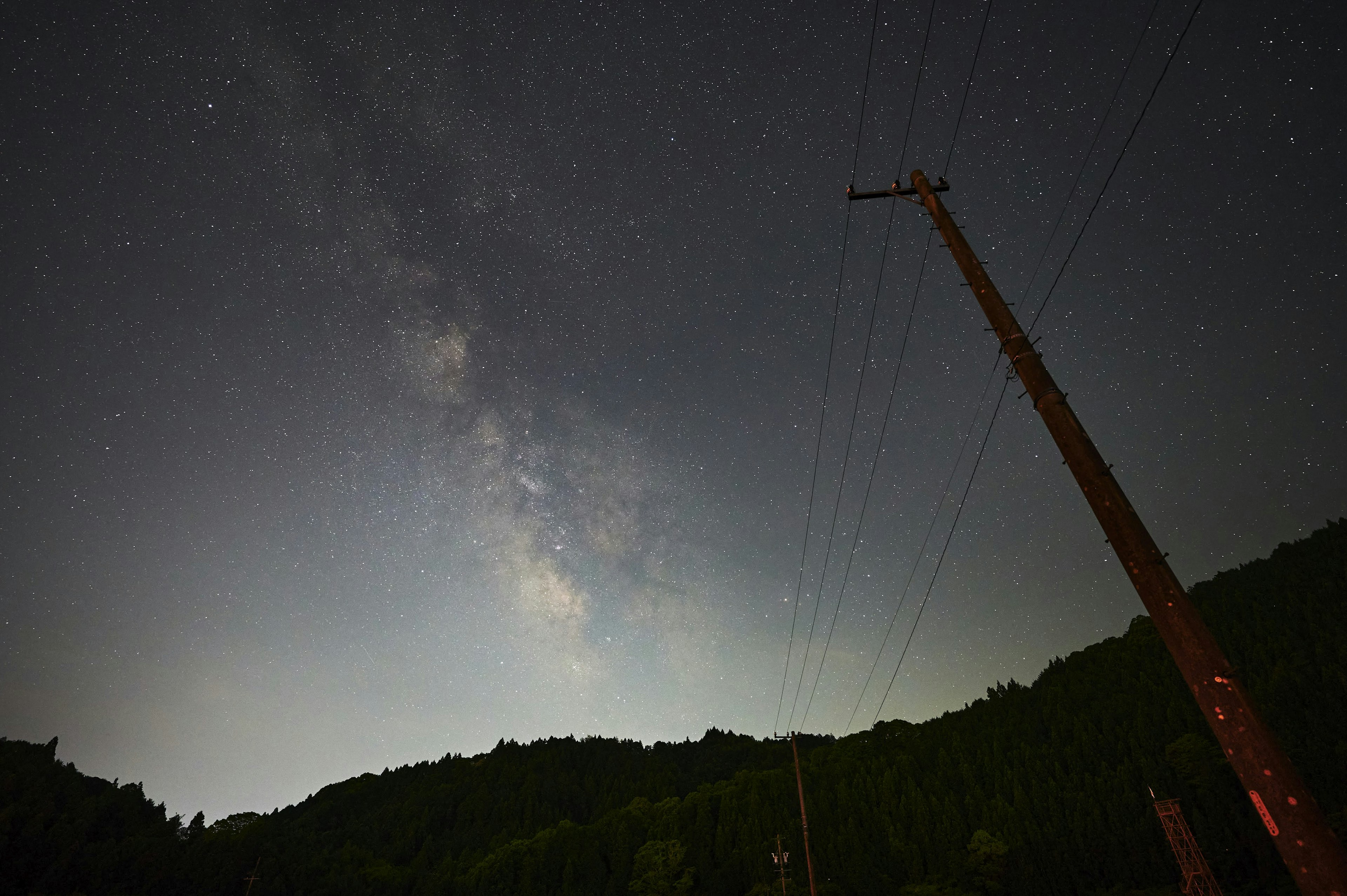 Paesaggio notturno con cielo stellato e silhouette di montagna