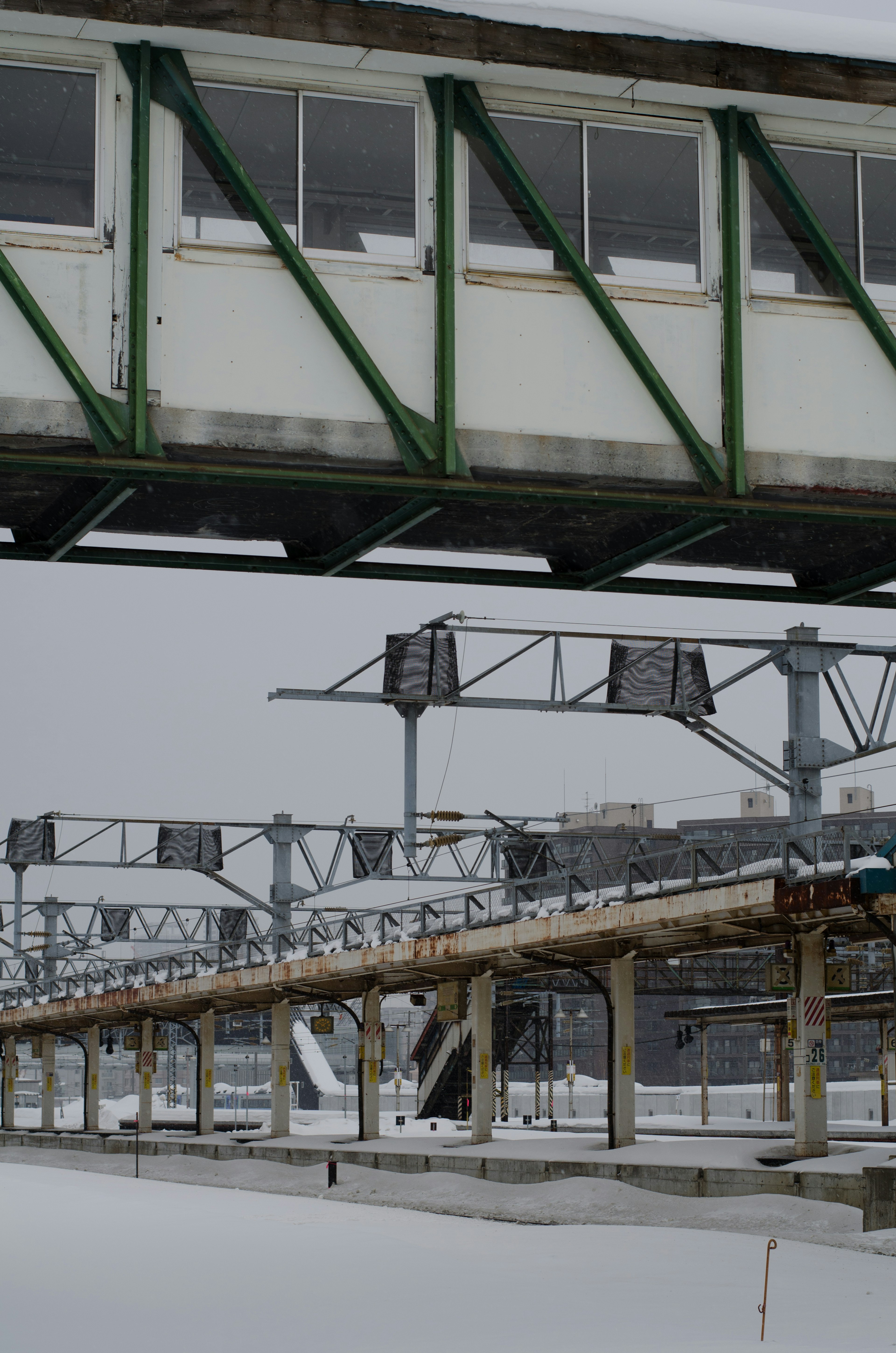 Snow-covered railway overpass with structural beams and supports