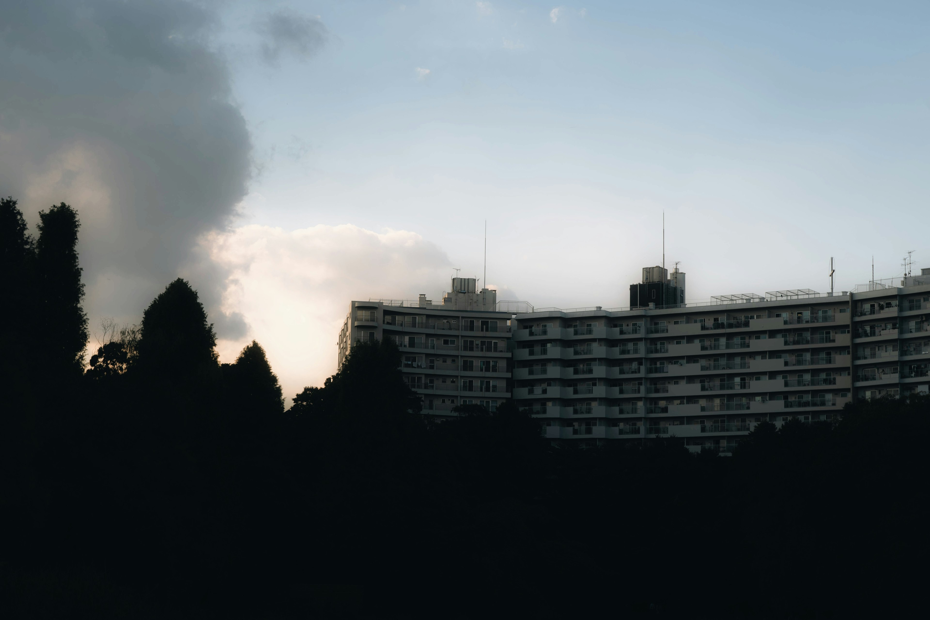 Silhouette of a building at dusk with clouds