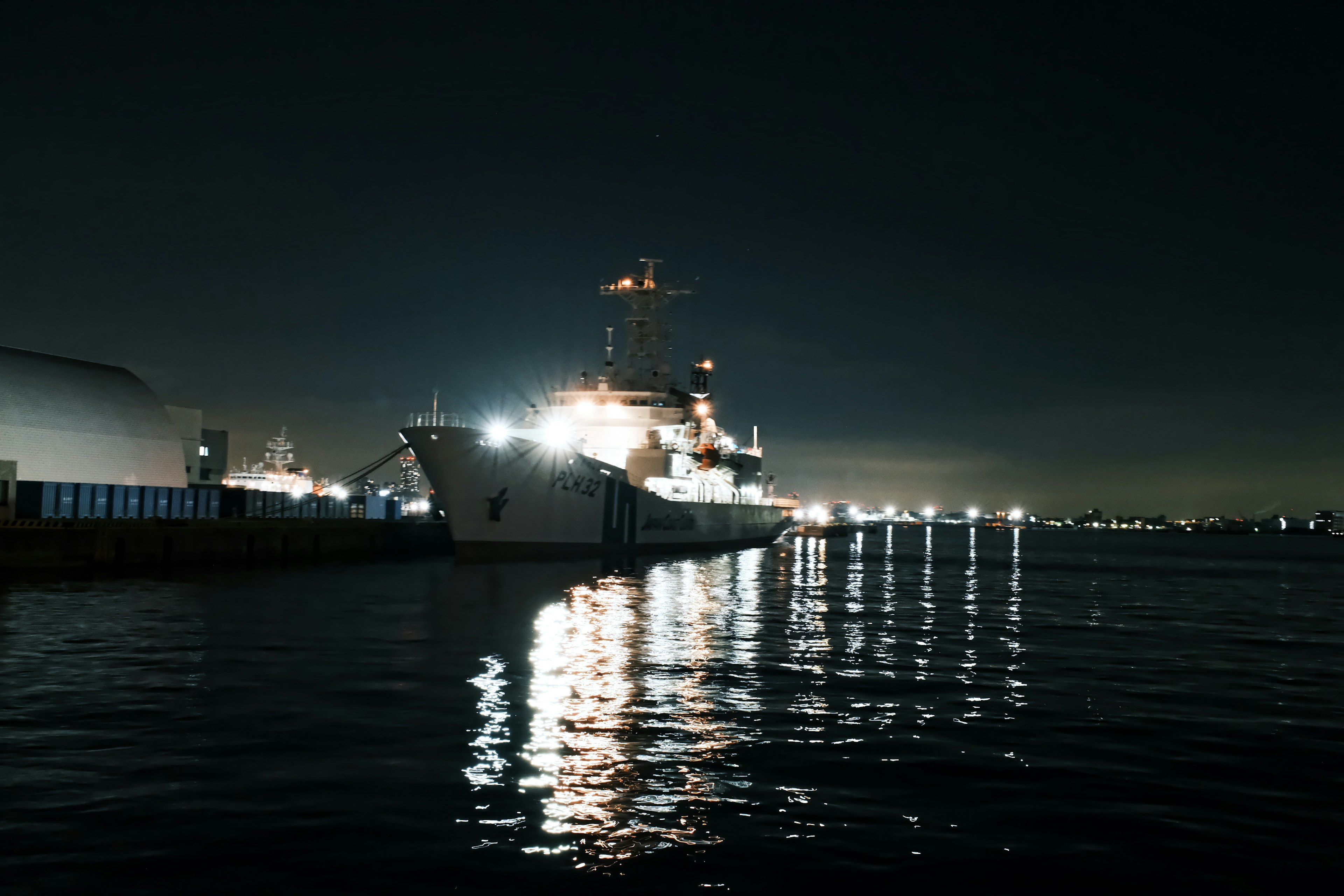 Ship docked at night with reflections on the water