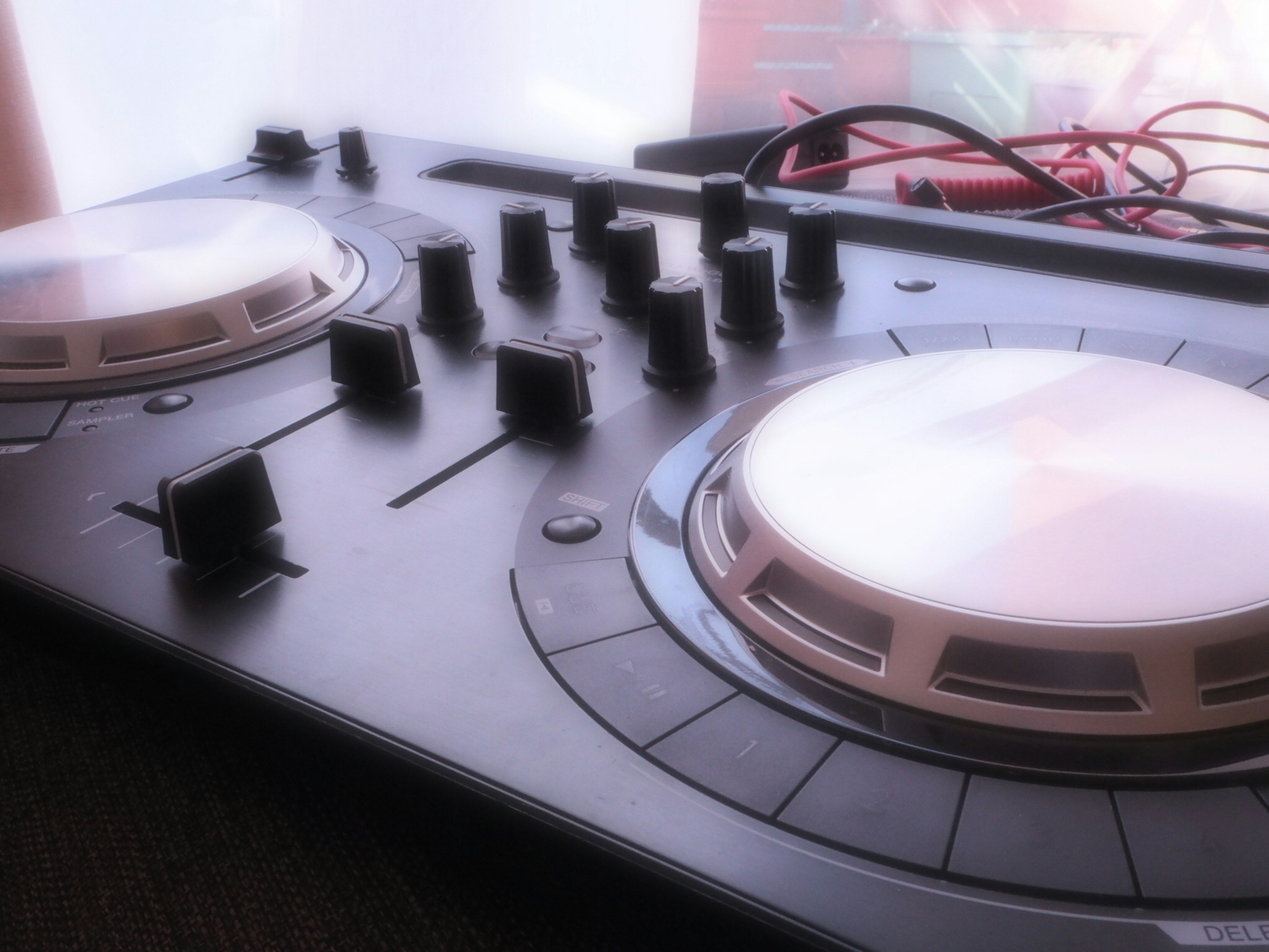 Close-up of a black DJ equipment featuring two turntables and multiple knobs