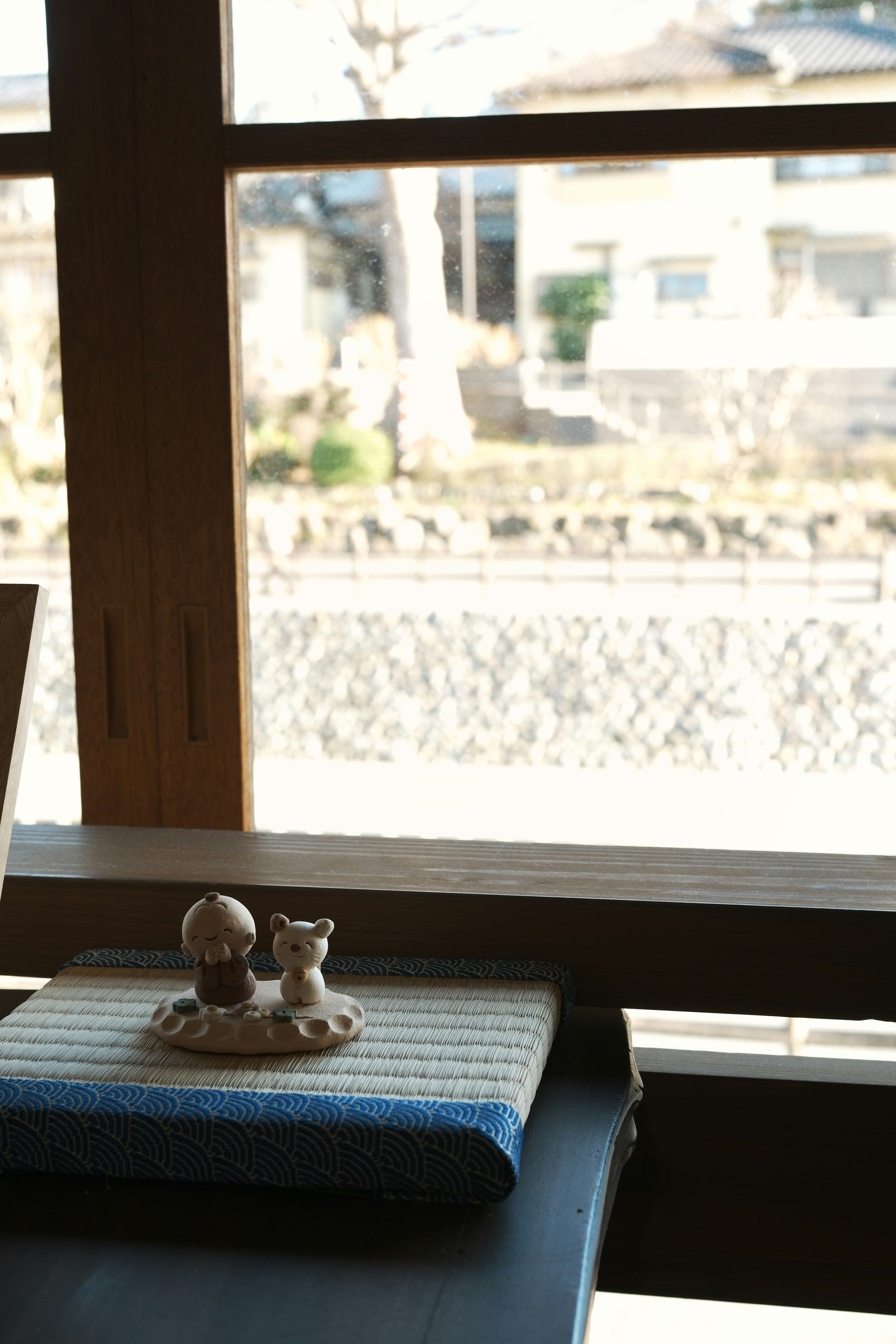 Figurines en céramique et un tissu japonais sur une table près de la fenêtre