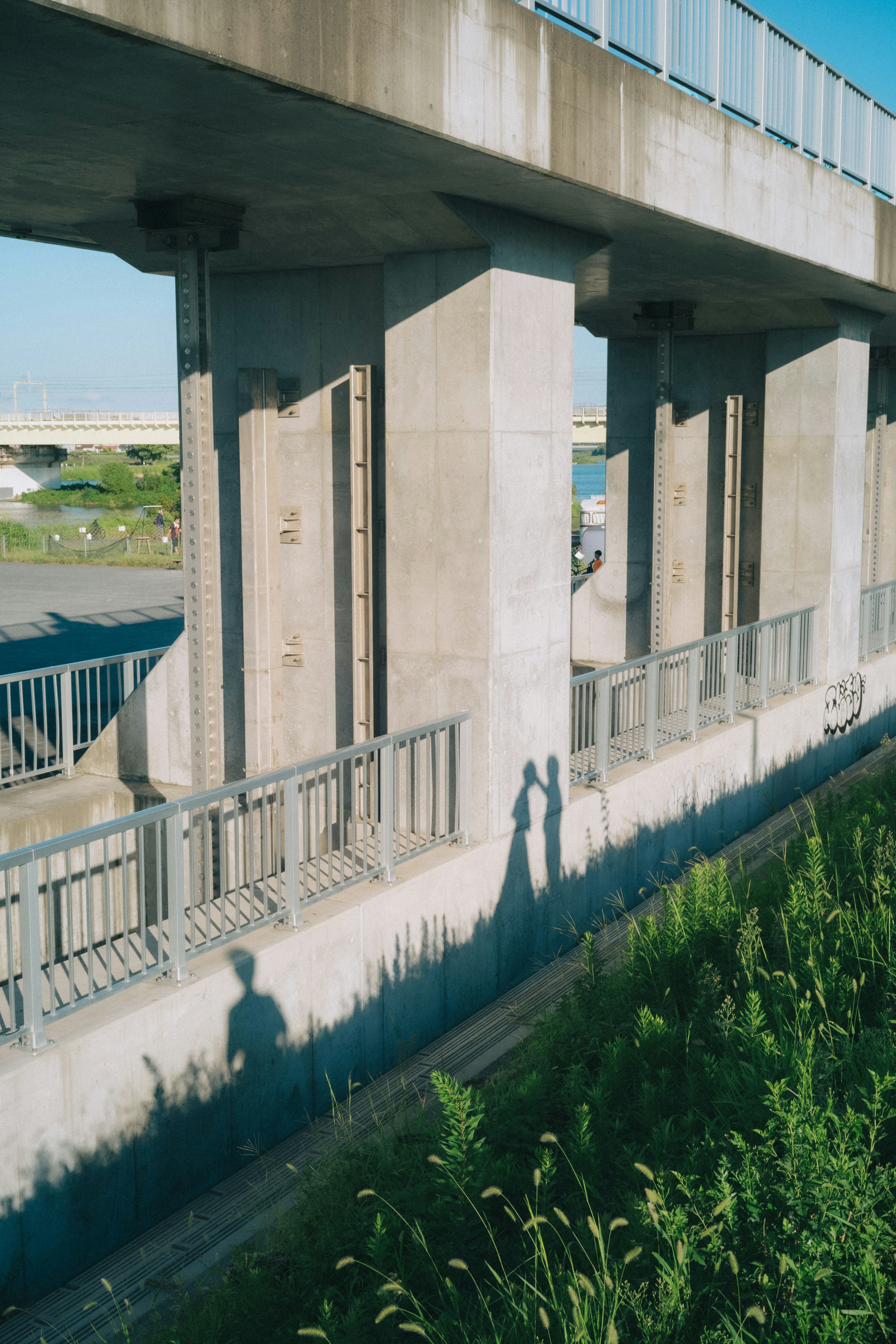 Sombras de una pareja bajo un puente de concreto