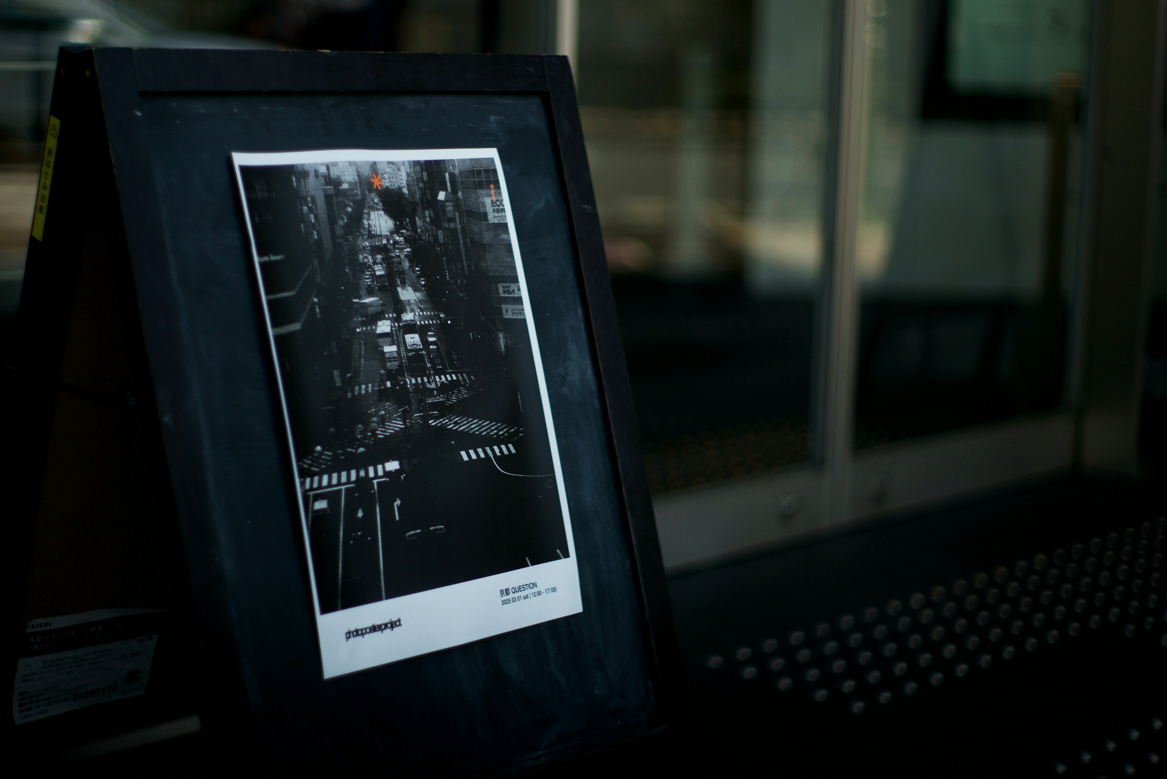 A framed photo on a table showing a cityscape in dark tones