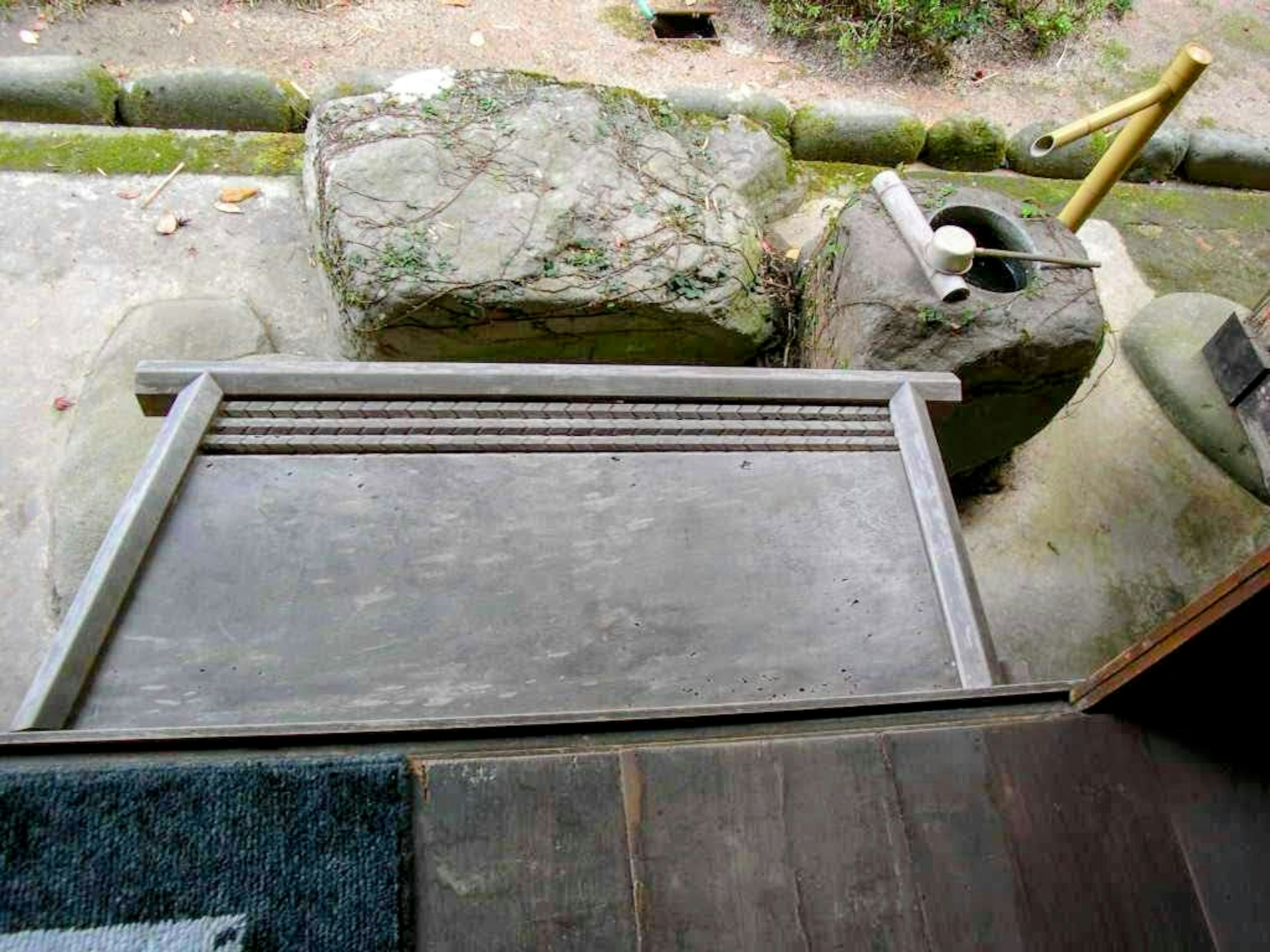 Wooden ramp and stone water basin in a Japanese garden setting