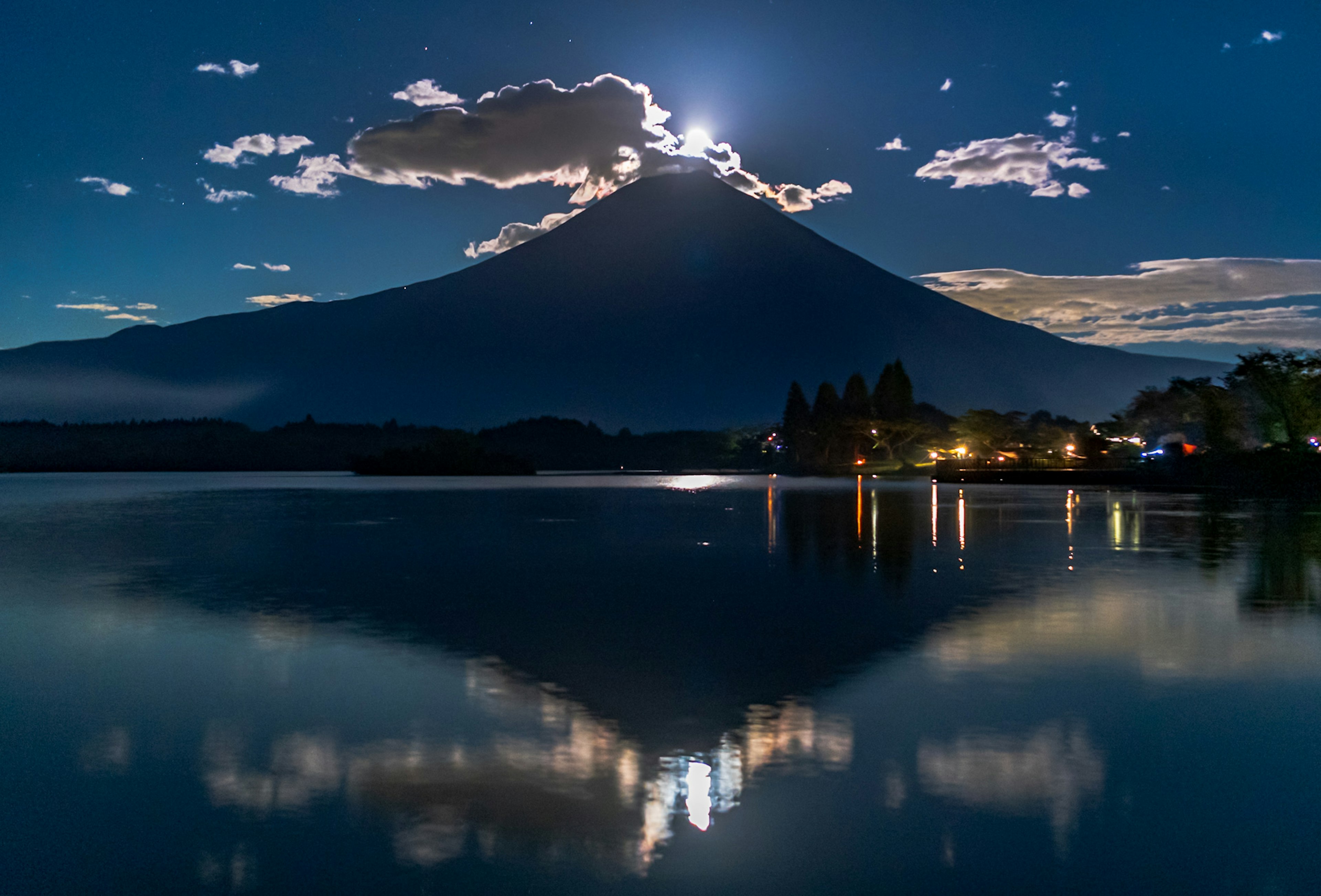 Vista nocturna del monte Fuji con su reflejo en el lago