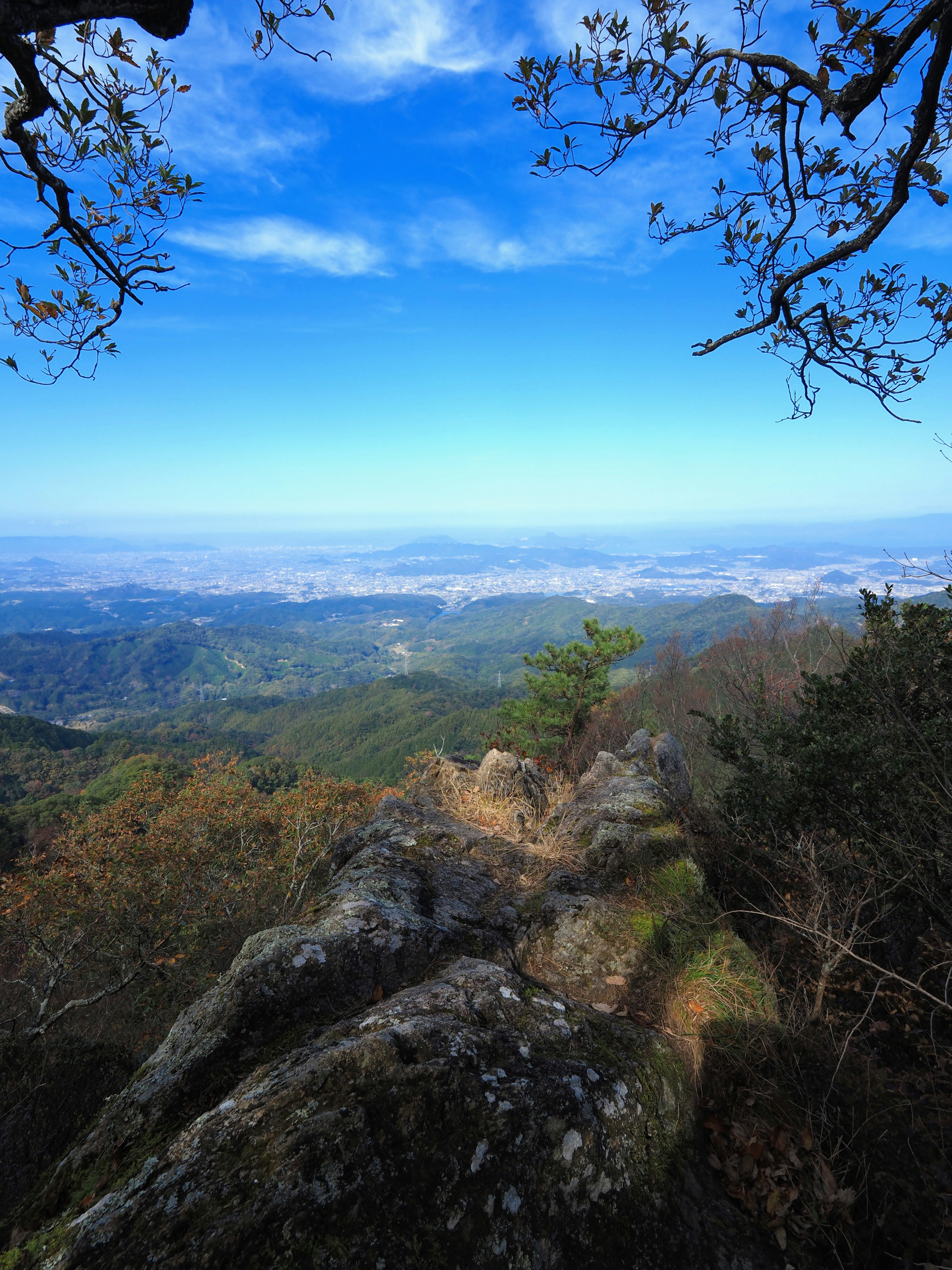 Point de vue rocheux sur des montagnes vastes et un ciel bleu clair