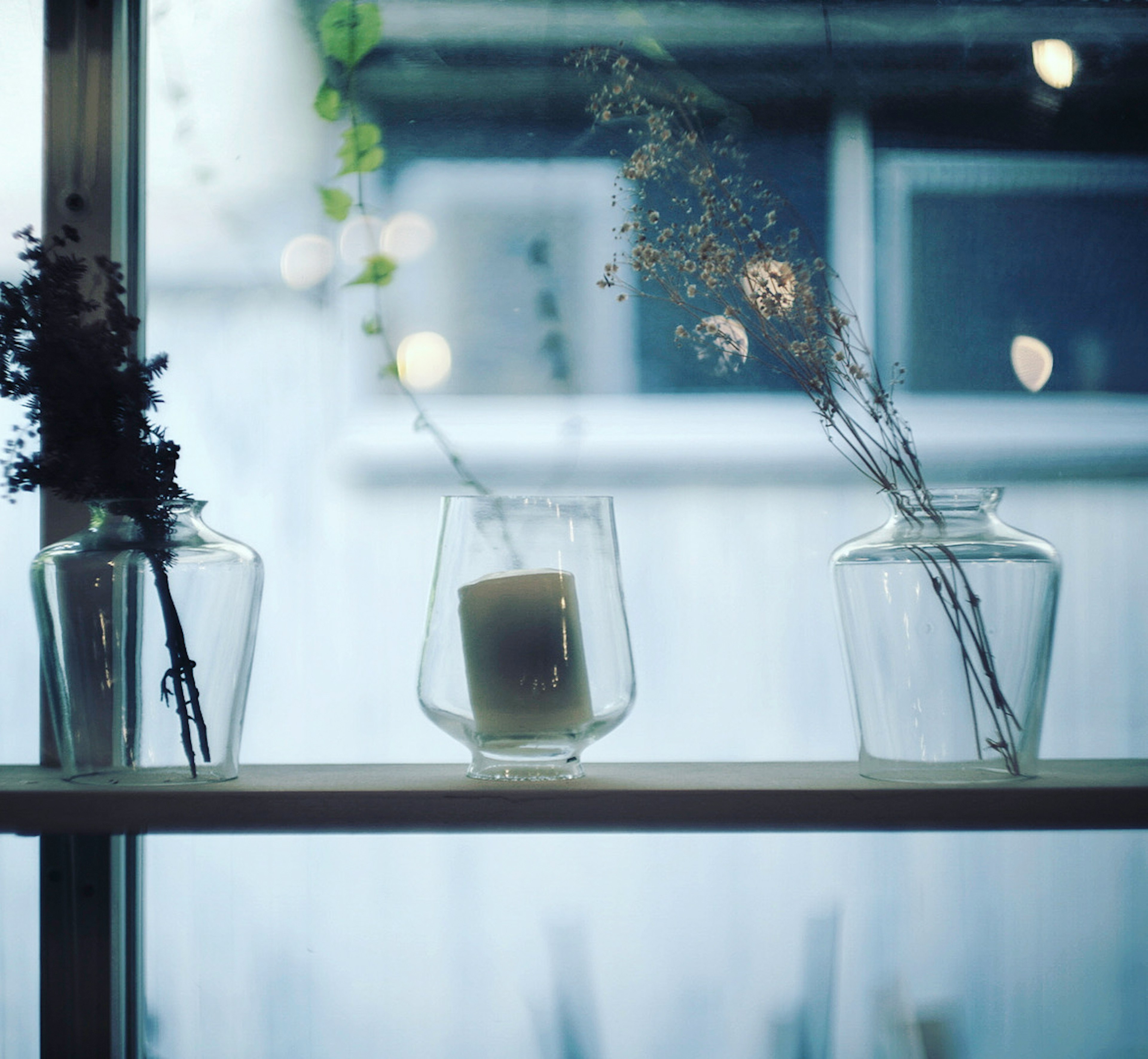 Elegant display of glass vases and a candle on a windowsill