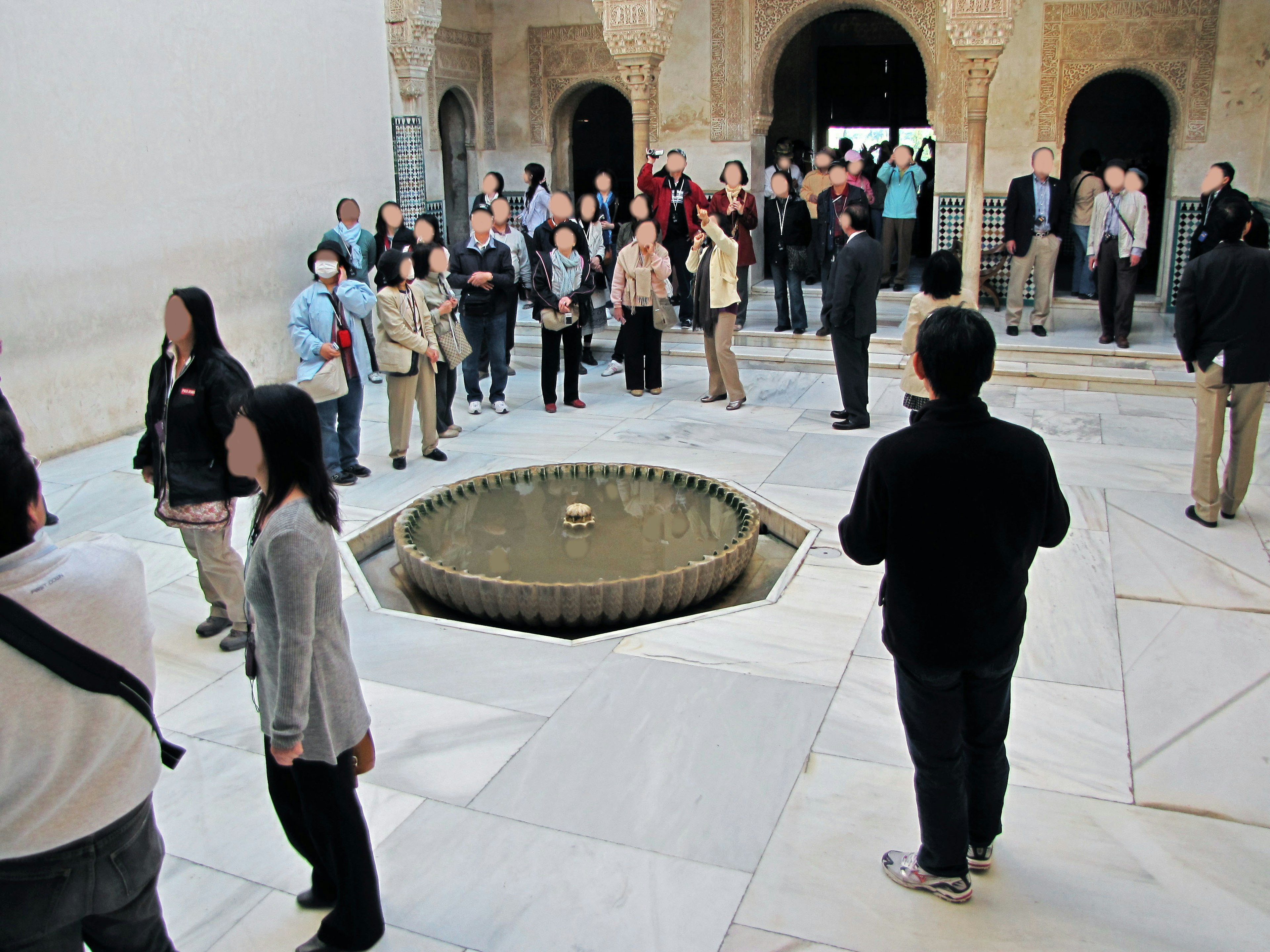 Tourists gathered in a palace courtyard featuring a central fountain