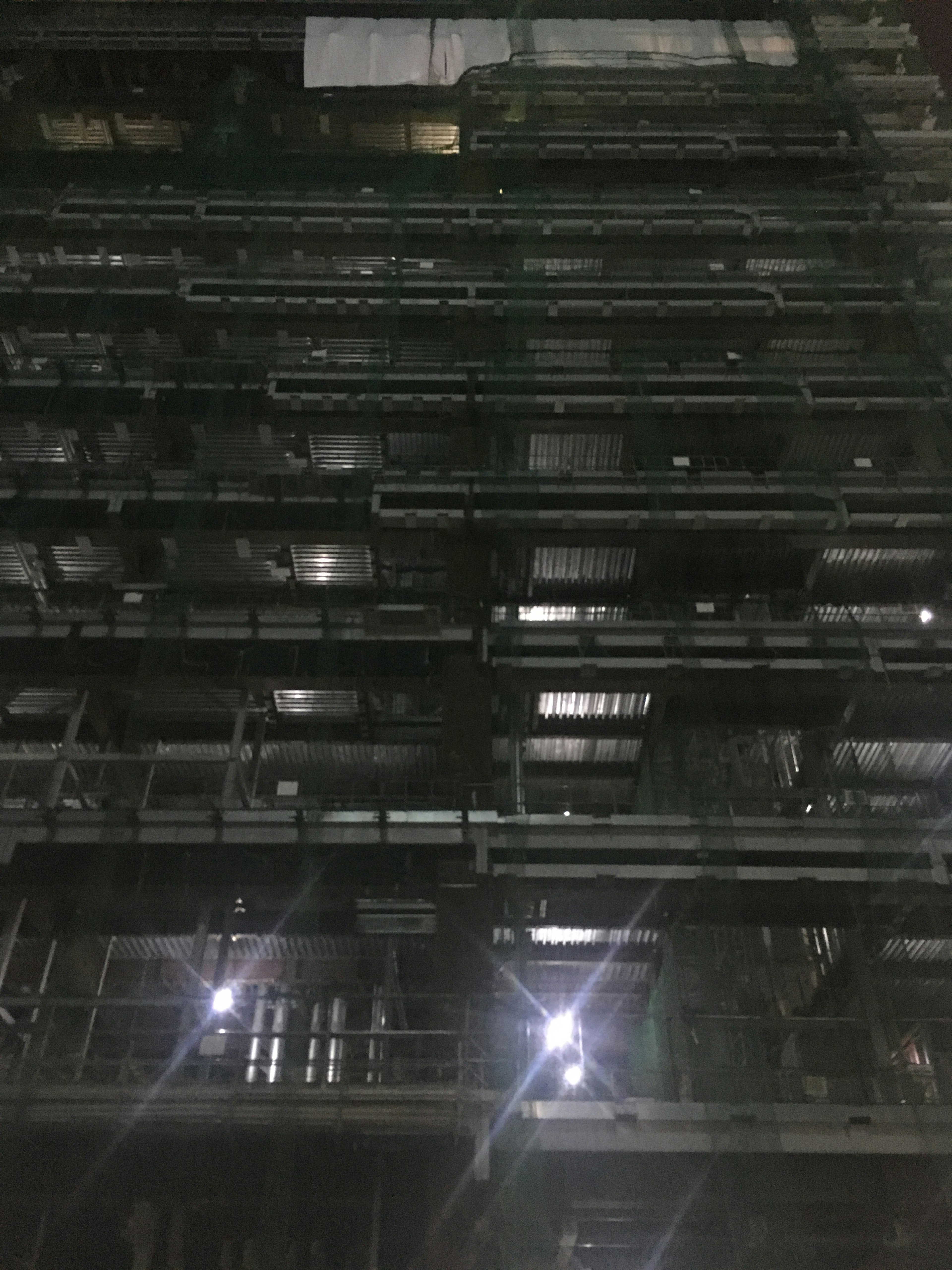 Vue nocturne de la façade d'un bâtiment avec éclairage et structure visibles