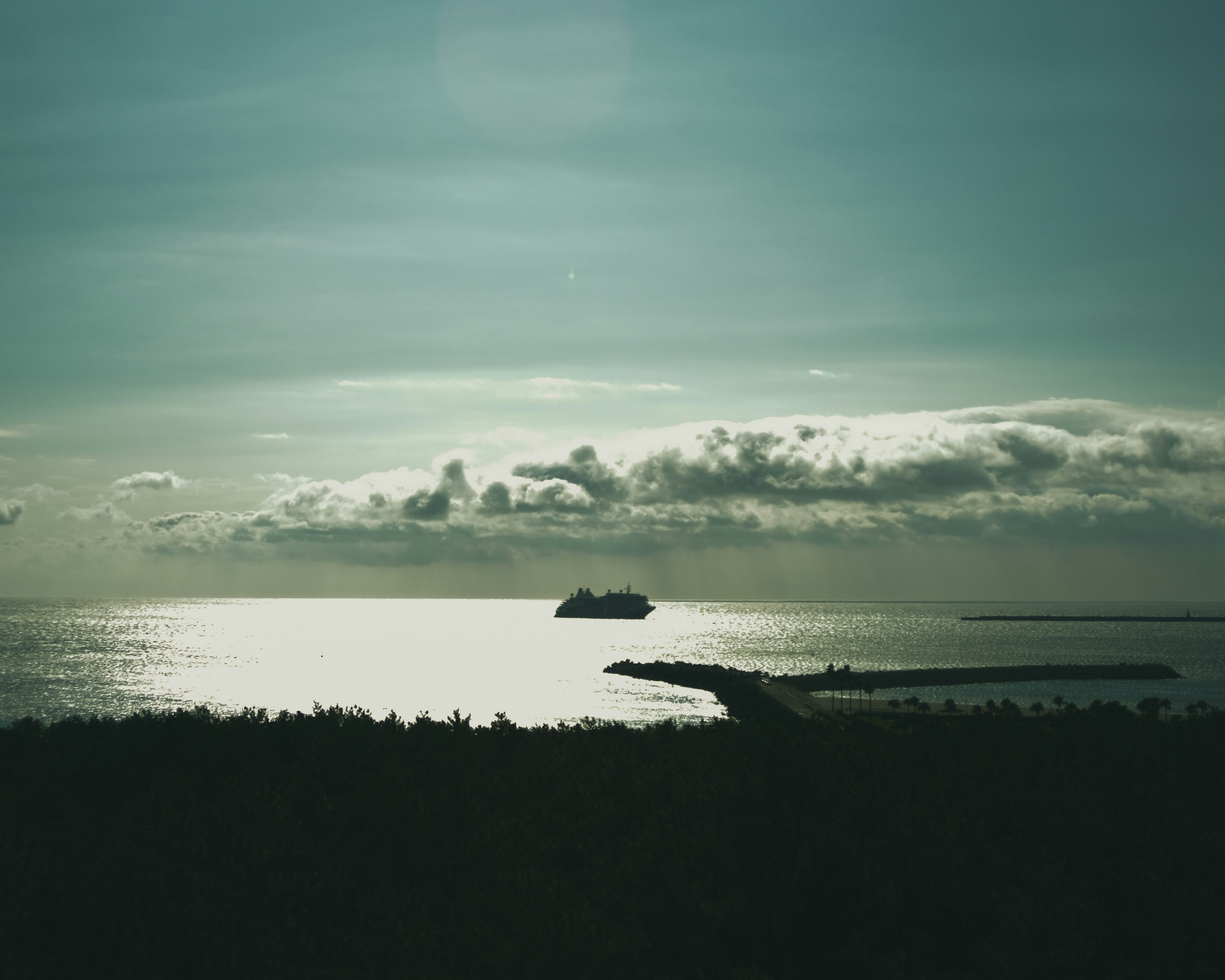 Vista serena del océano con un barco y un cielo azul