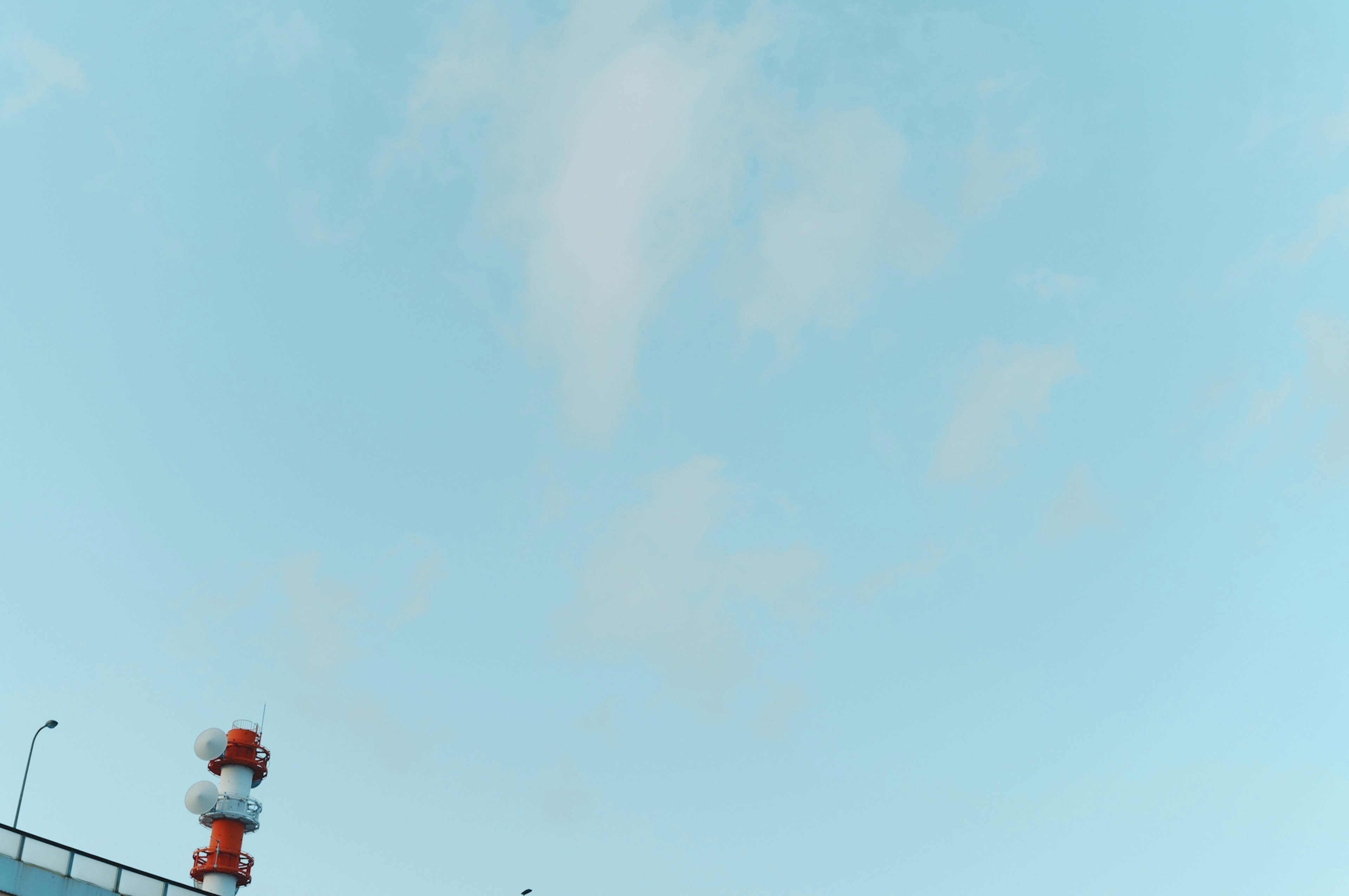 Blue sky with white clouds and a red and white chimney