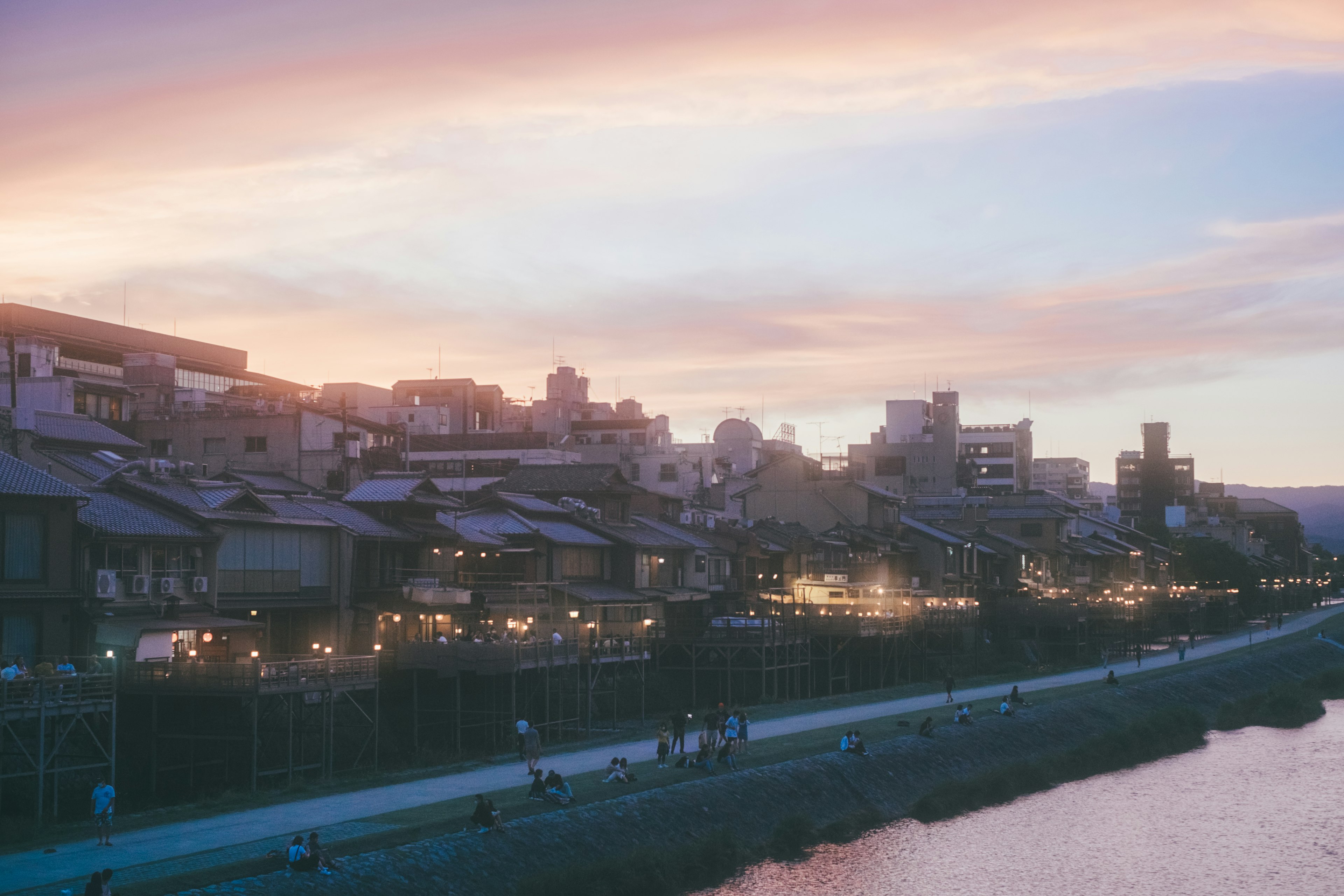 夕暮れの京都の川沿いの風景 古い建物と街灯が並ぶ