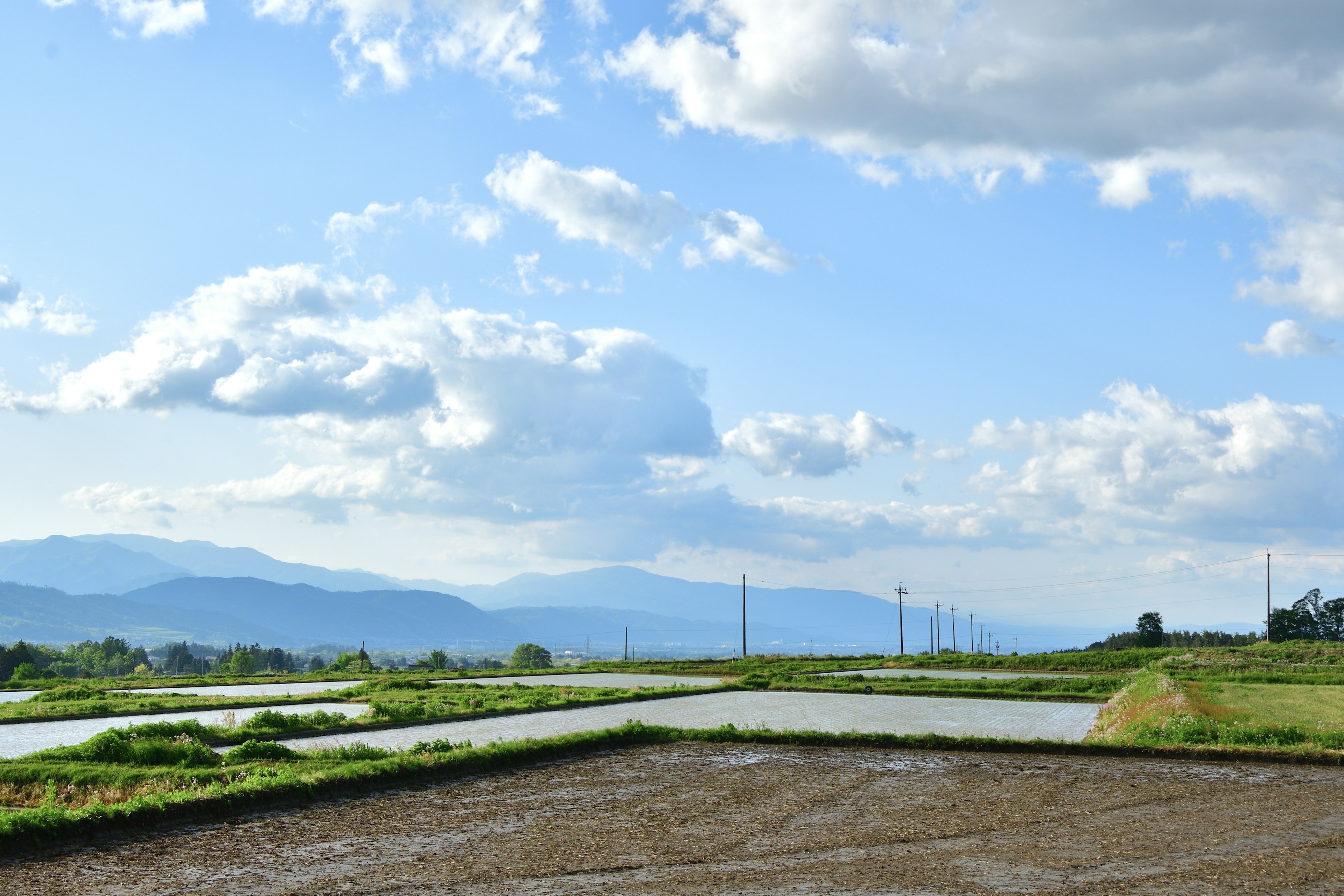 青空と雲が広がる田園風景の写真