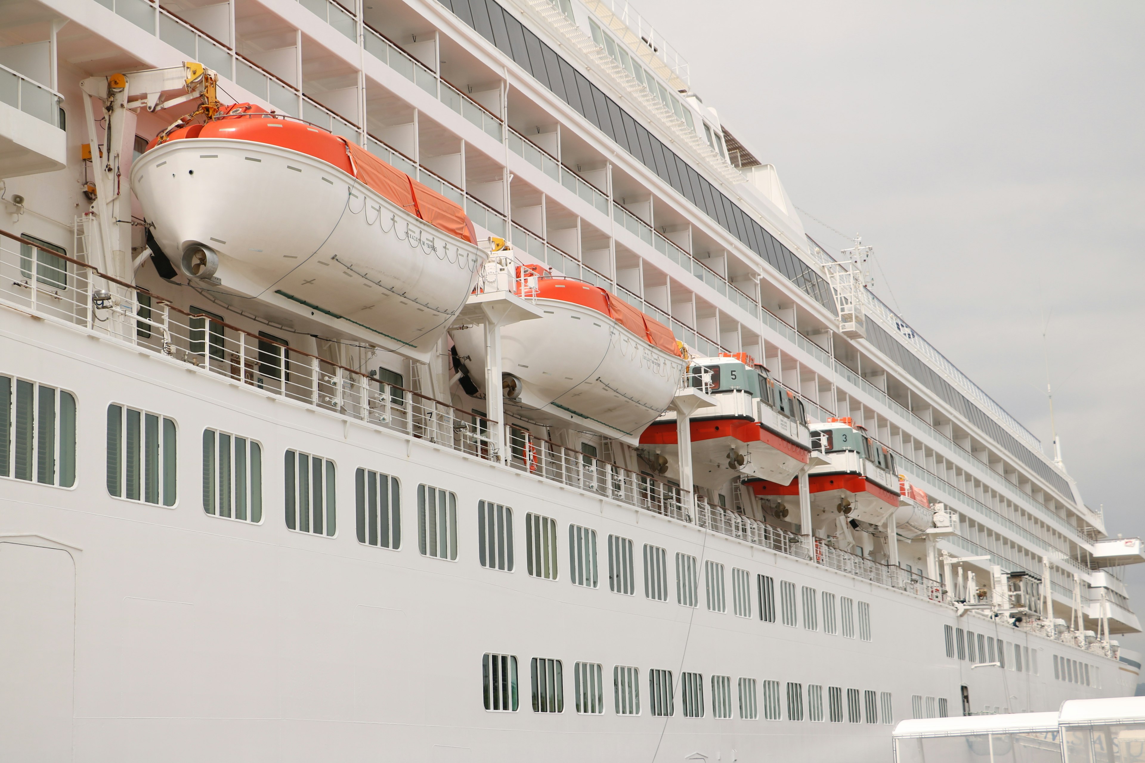 Side view of a cruise ship with lifeboats and windows