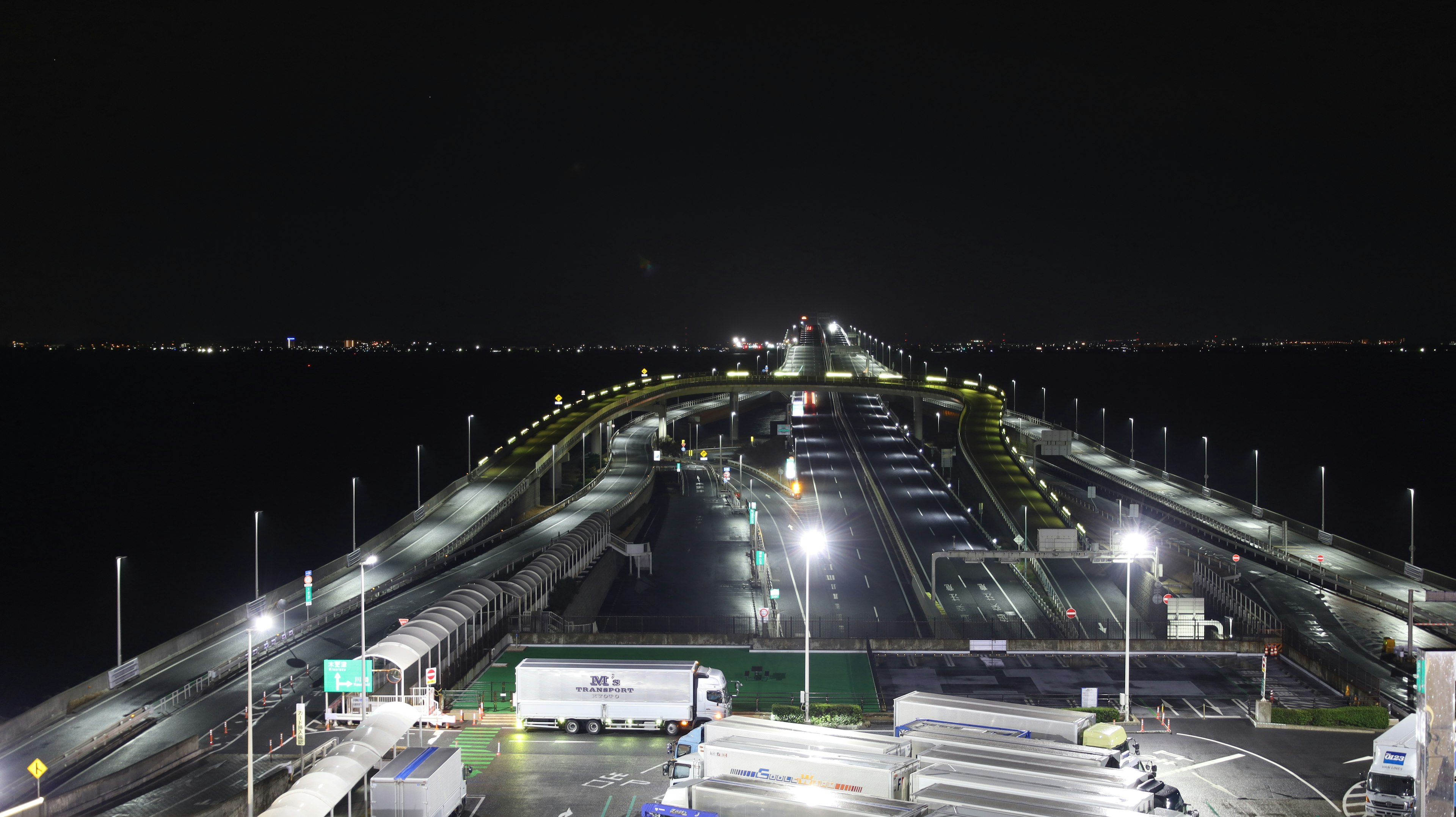 Pemandangan malam jembatan dengan pencahayaan terang dan jalan tol