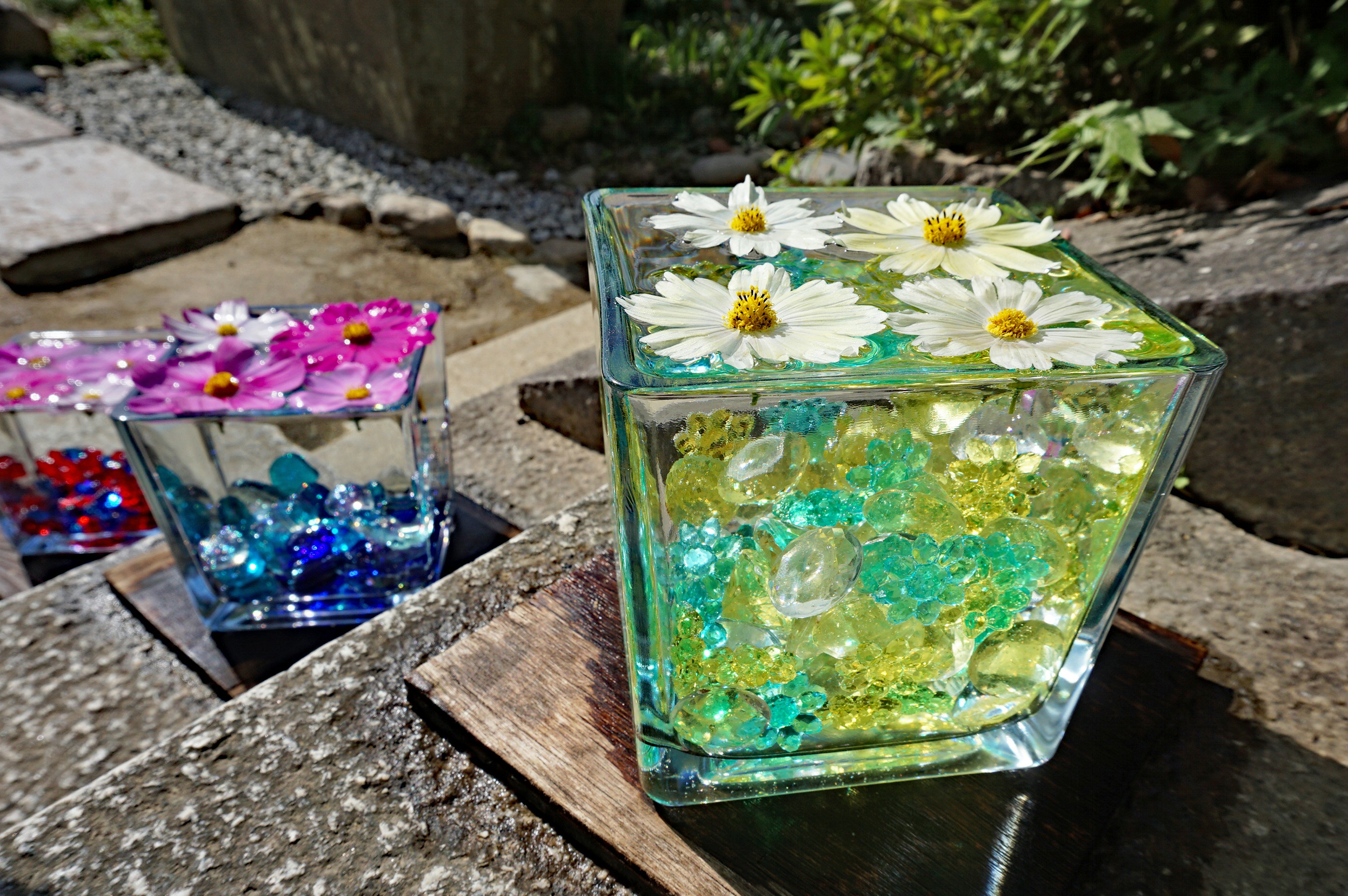 Scatola di vetro trasparente riempita di fiori colorati e decorazioni in cristallo