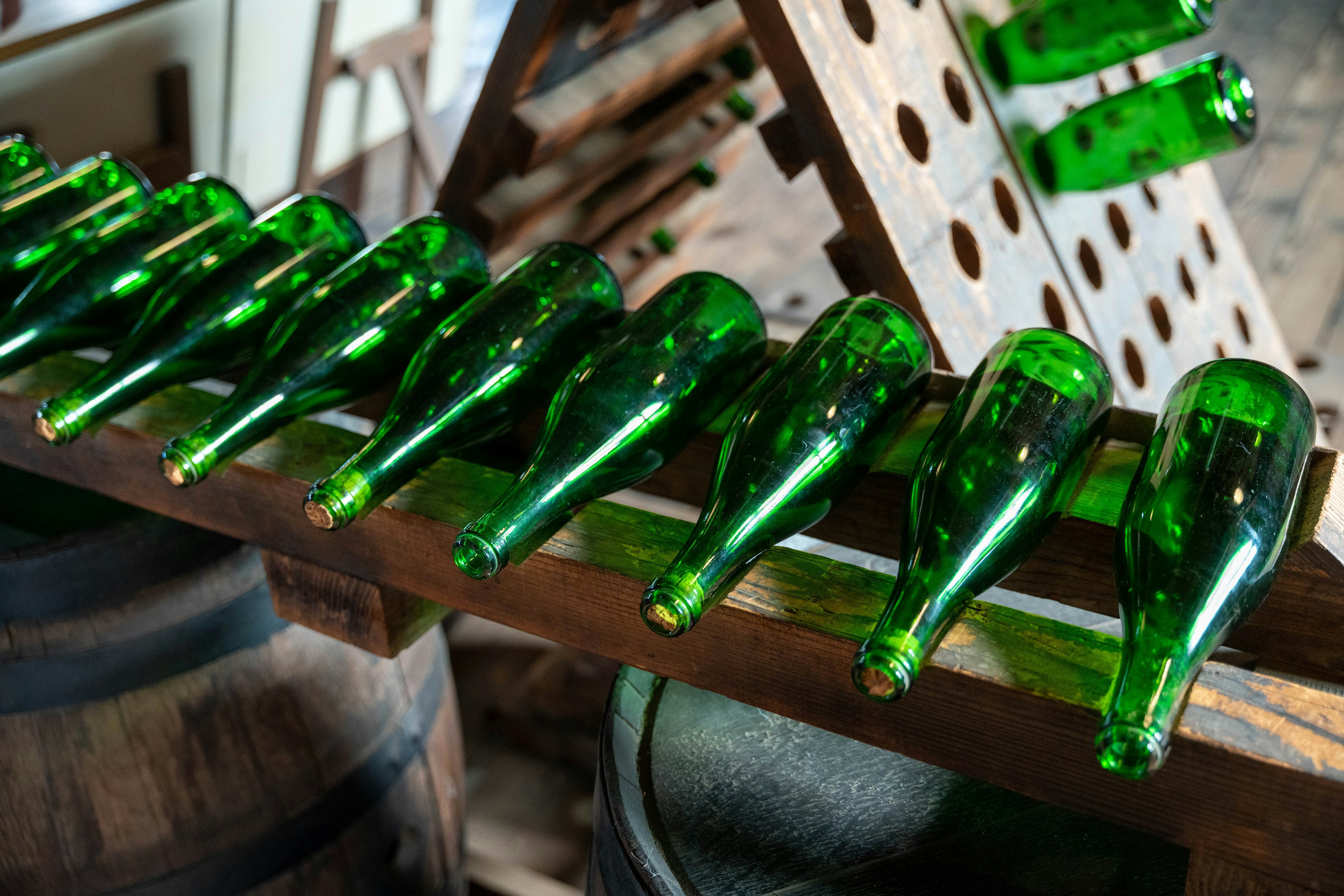 Image of green bottles arranged on a wooden rack