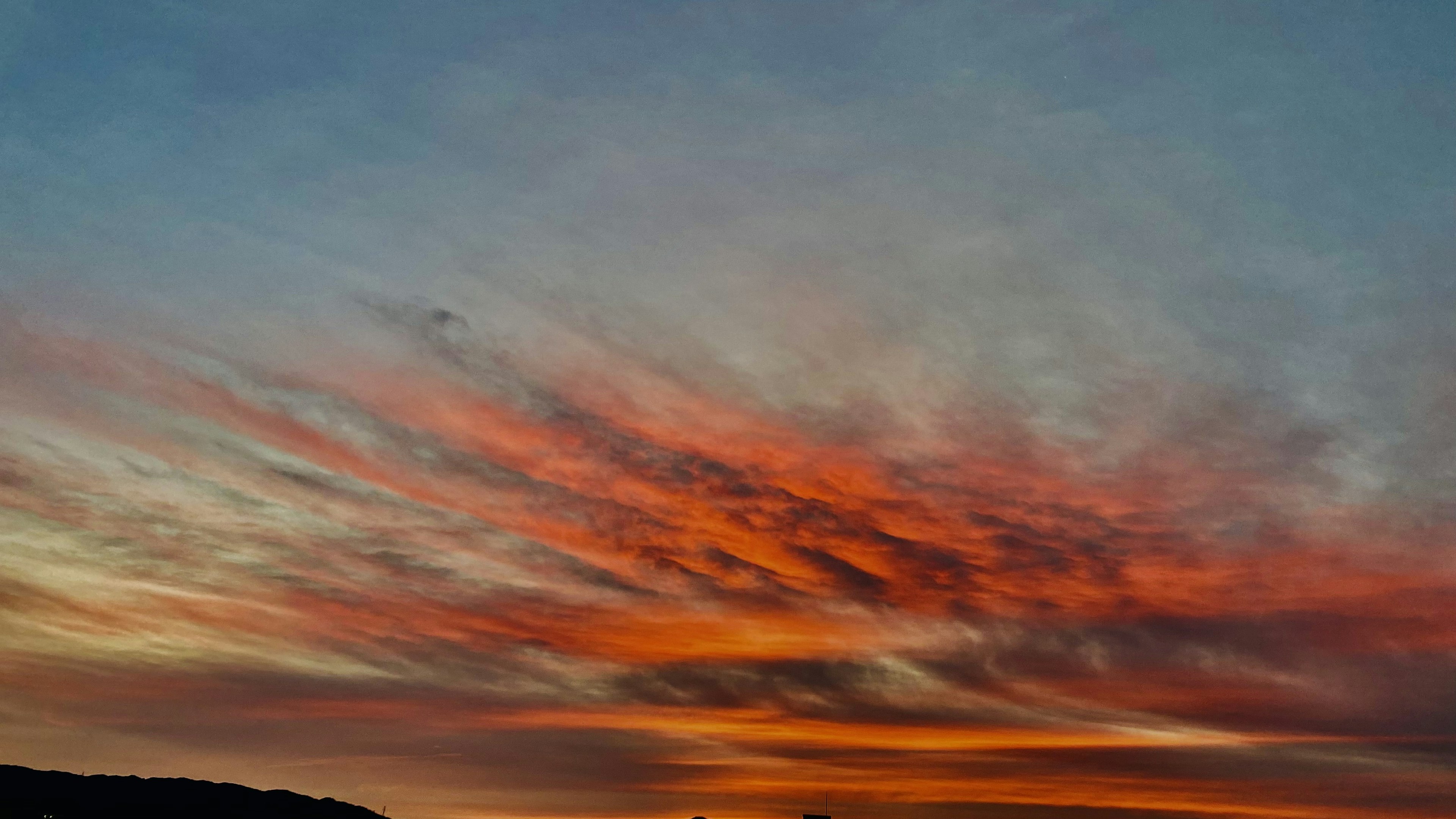 Atemberaubender Sonnenuntergangshimmel mit lebhaftem orange-blauen Farbverlauf