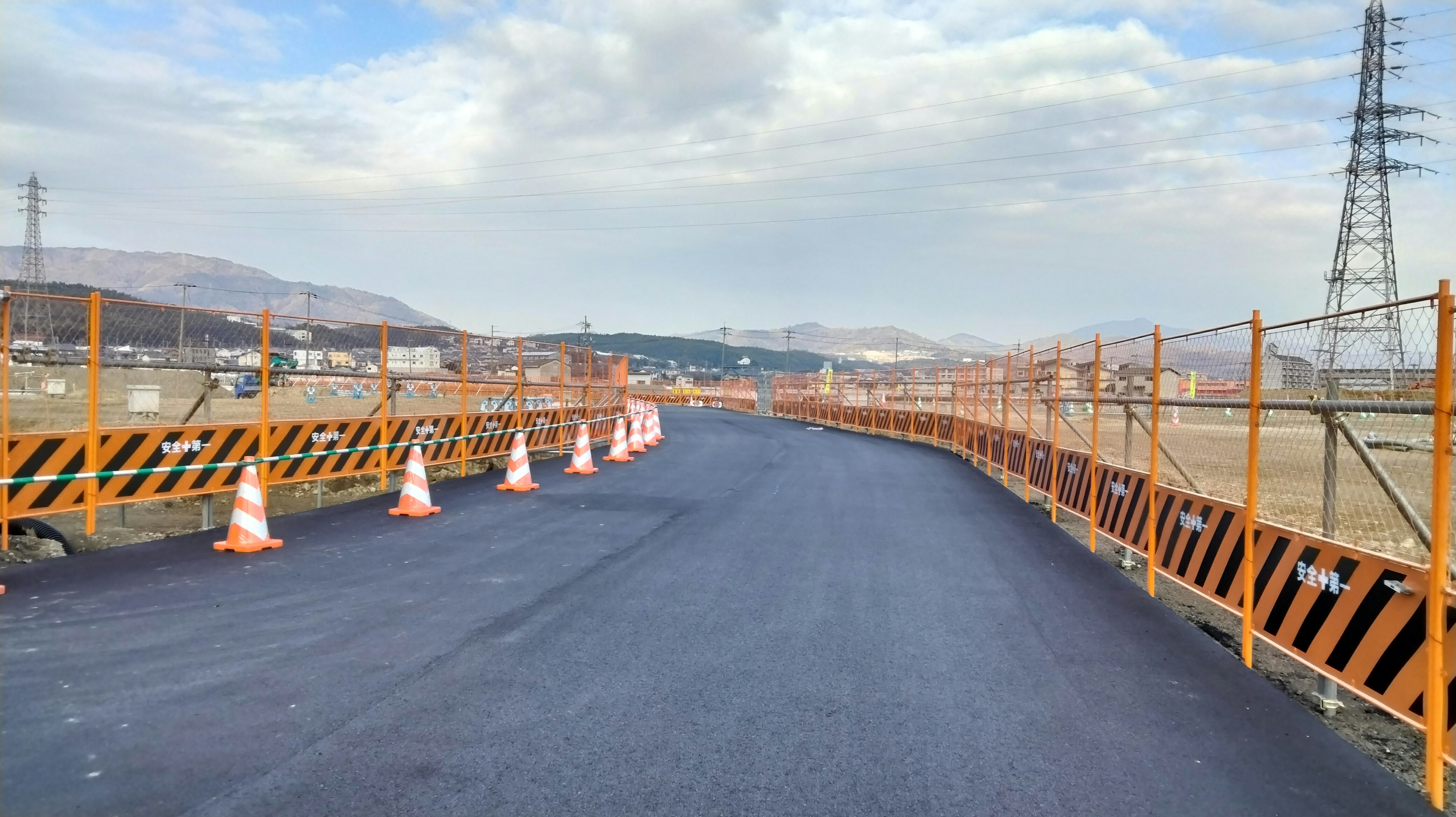 Cantiere con una strada recentemente asfaltata e coni arancioni