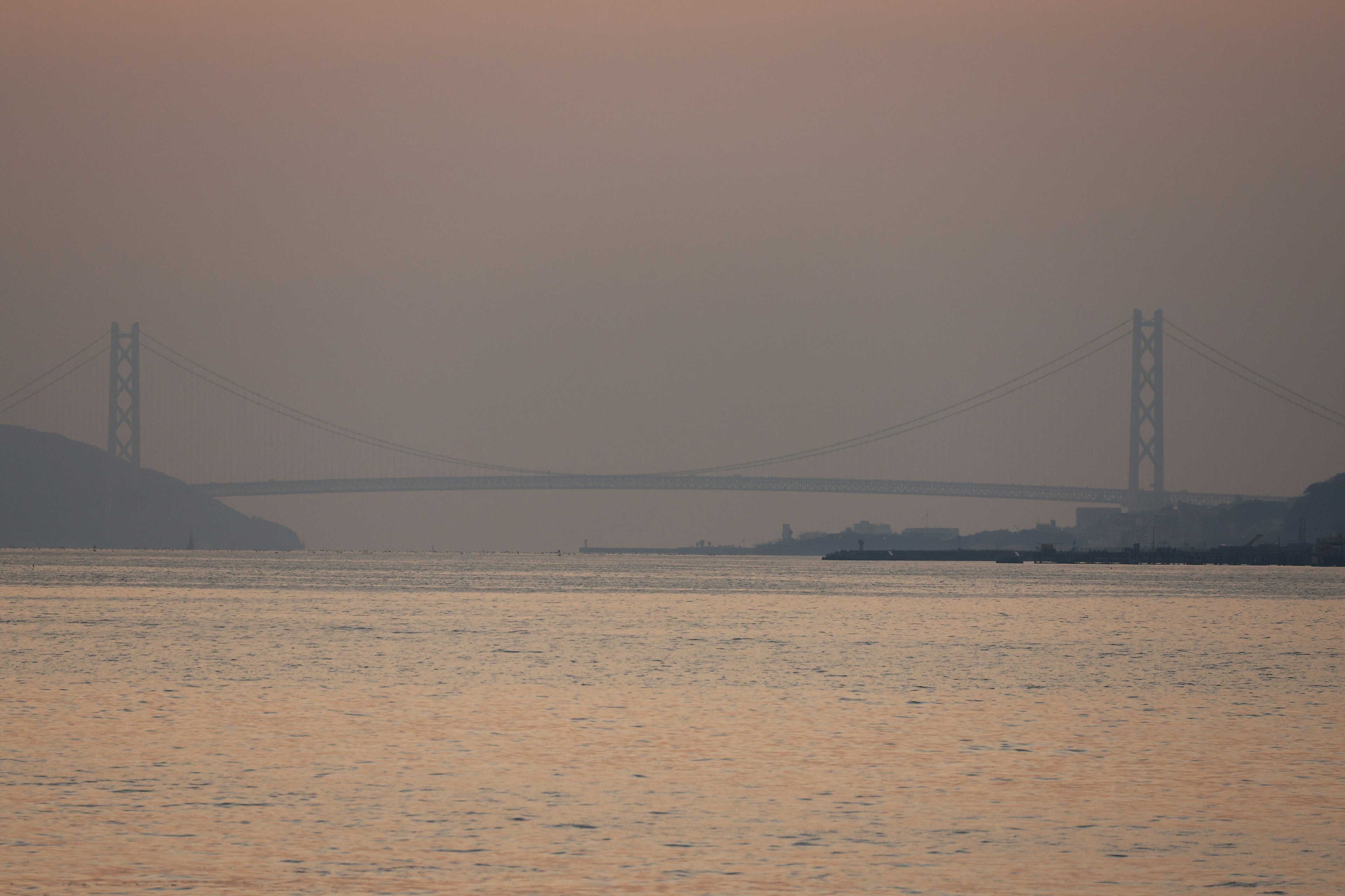 Silhouette einer Brücke über einen Fluss in der Dämmerung