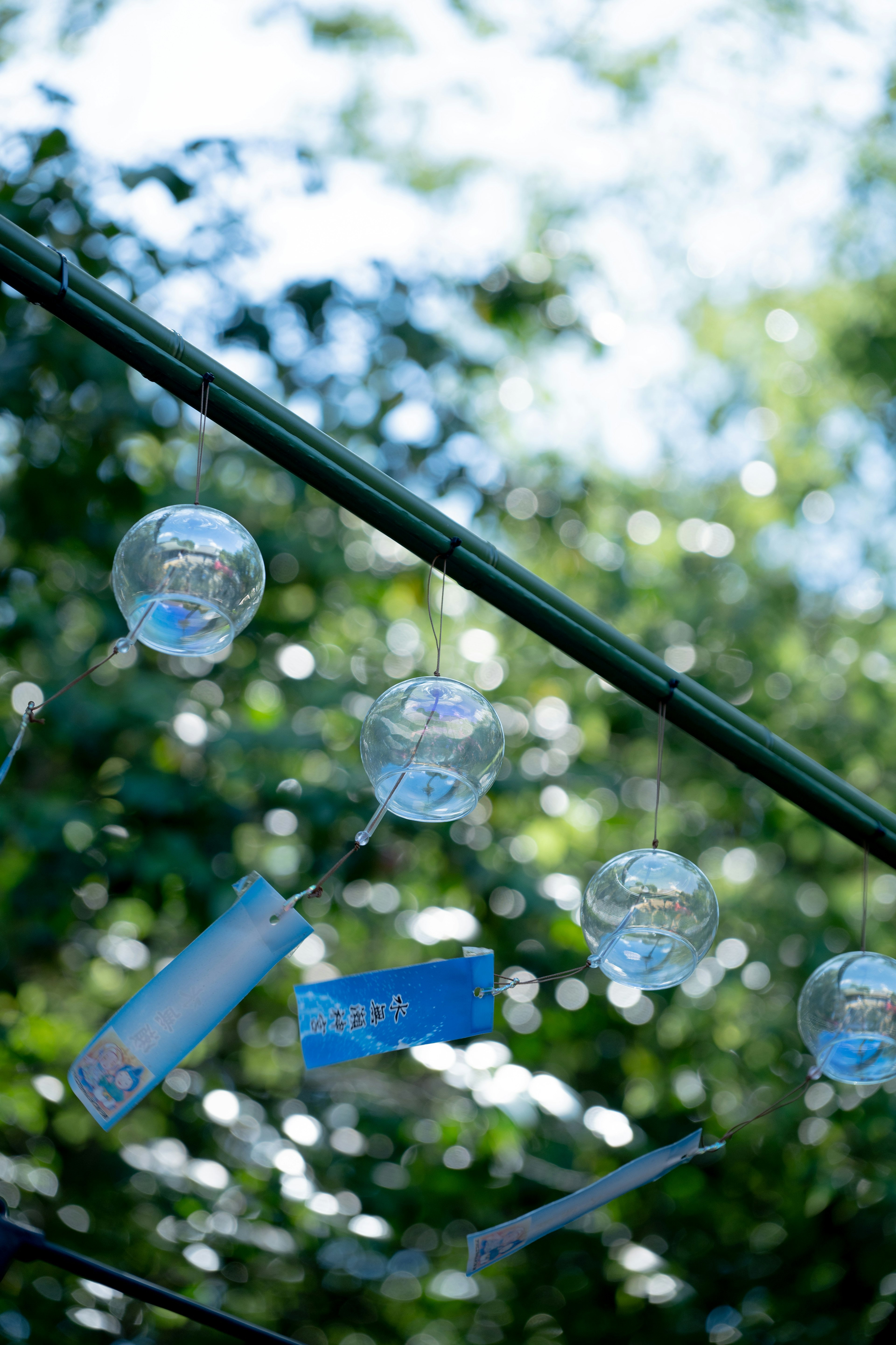 Transparente Windspiele, die unter dem blauen Himmel schwingen