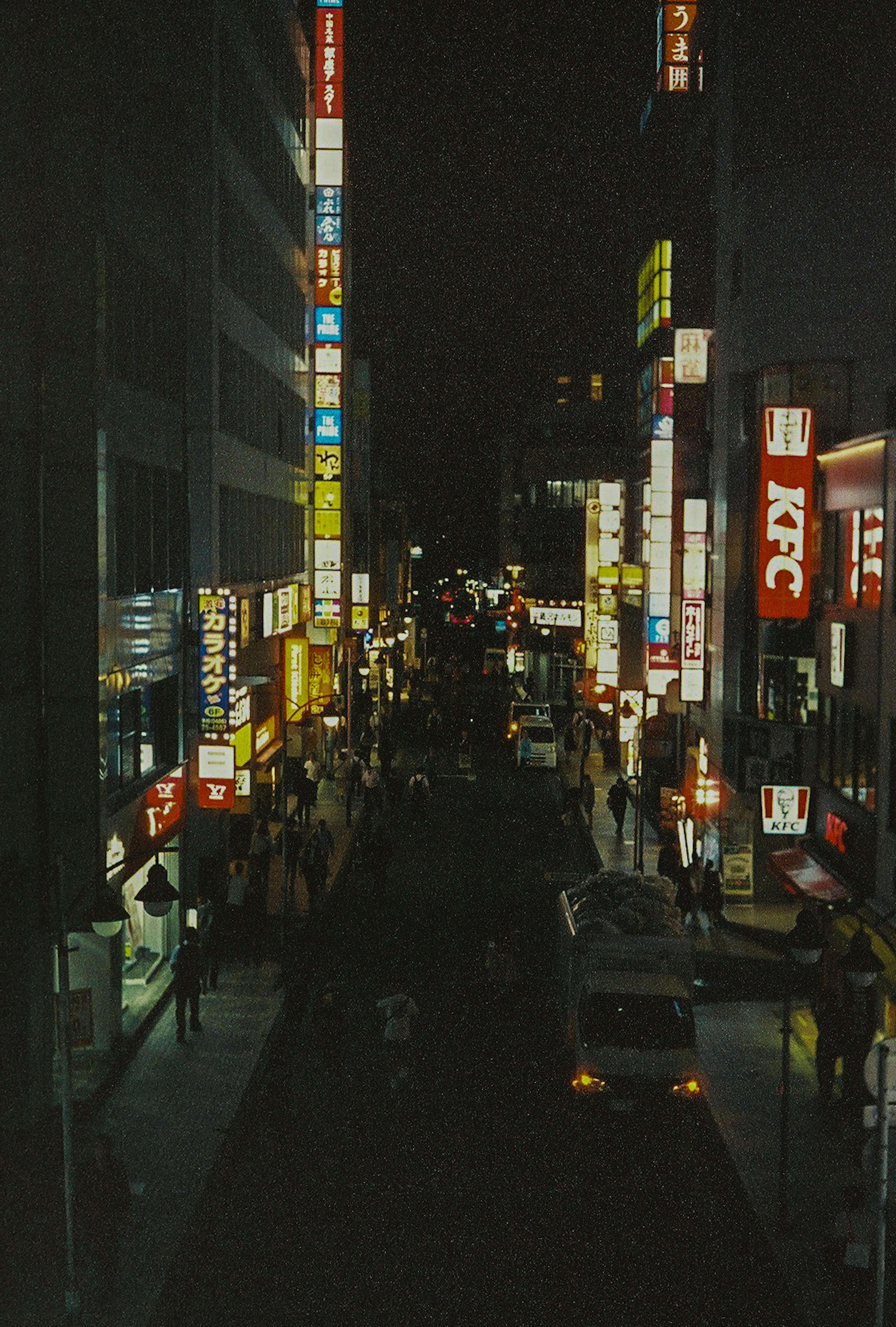 Vibrant city street at night with illuminated signs and bustling atmosphere