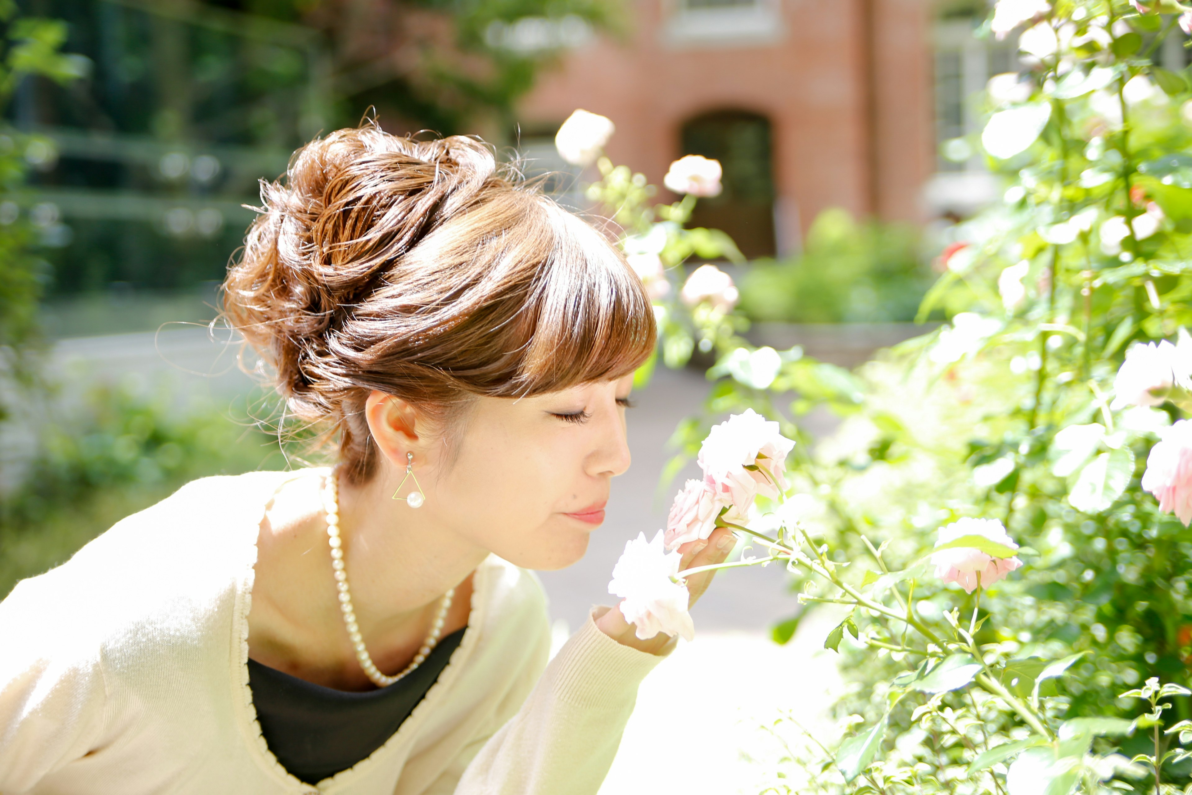 A woman smelling flowers in a beautiful garden