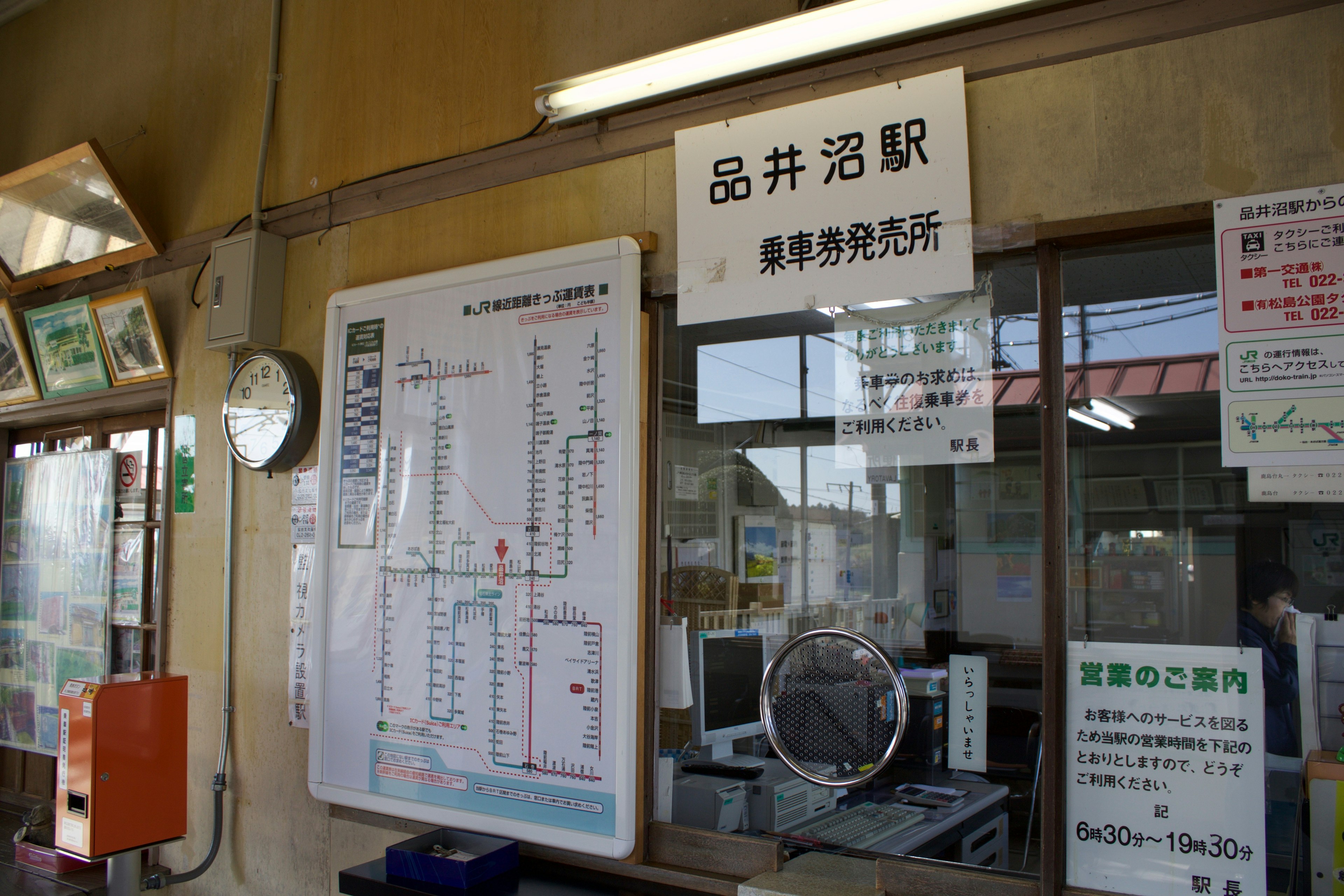 Vue intérieure de la gare de Shinaizuna montrant le nom de la gare et l'horaire