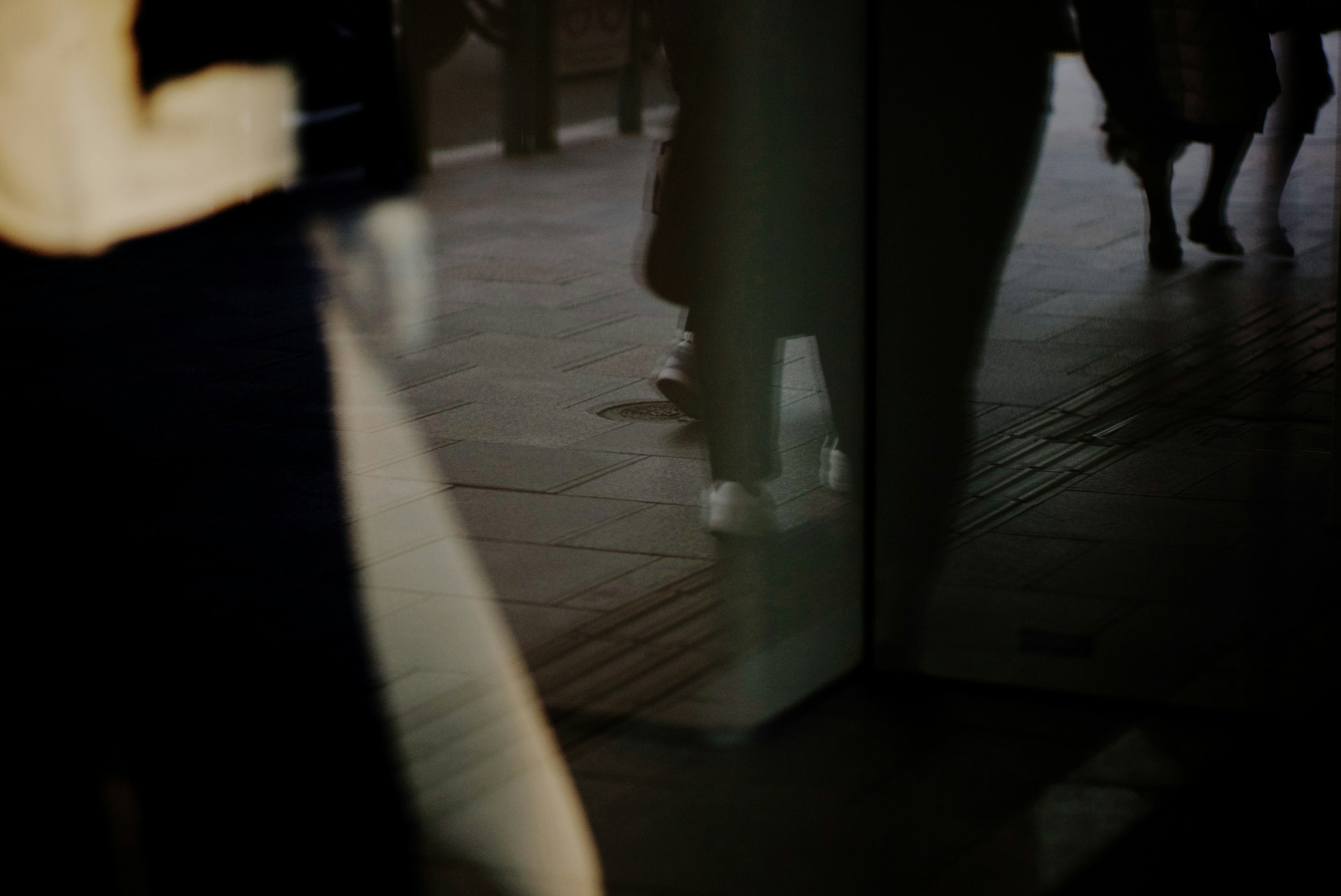 Reflections of people walking by a shop window