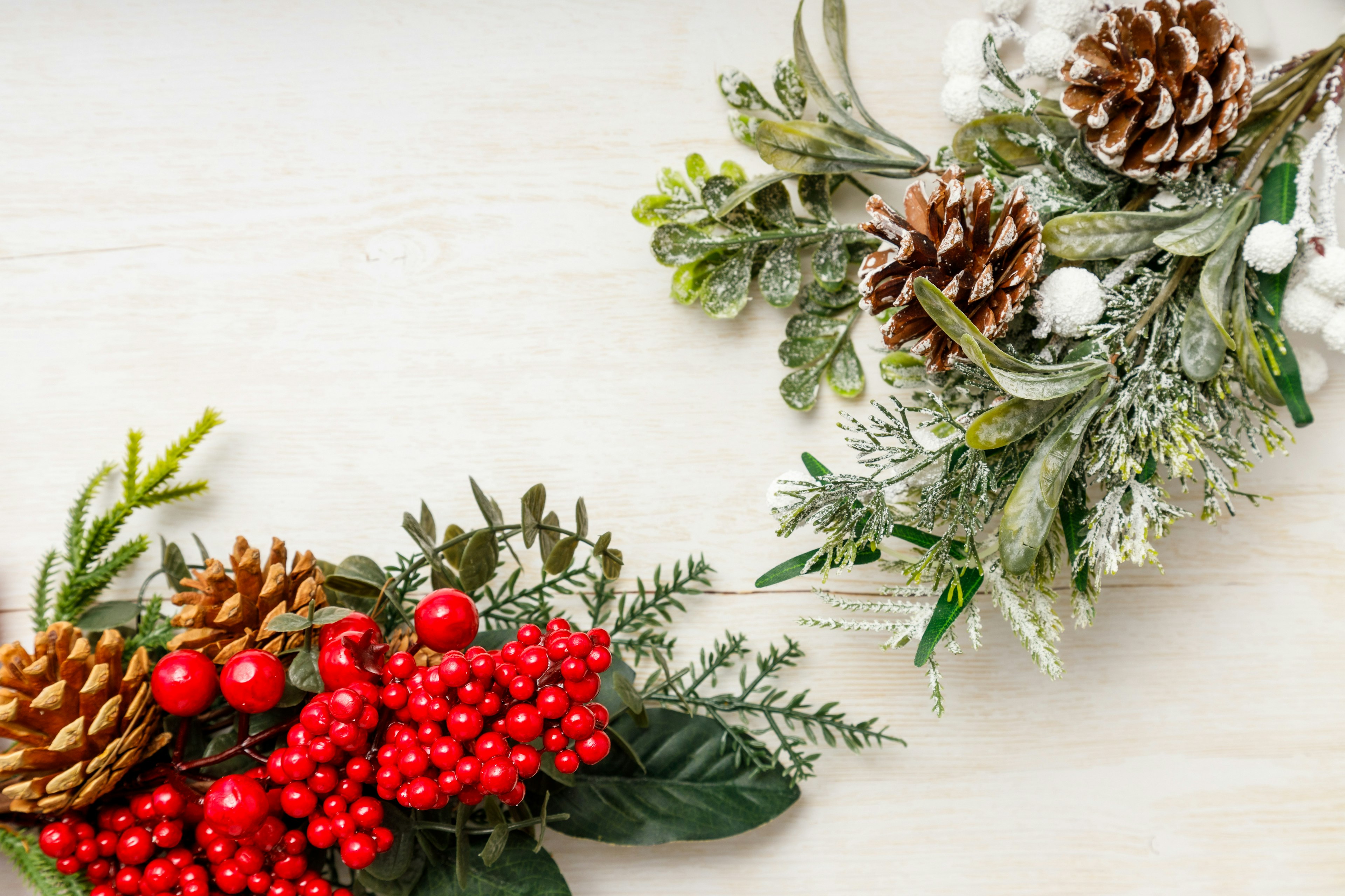 Decorazioni natalizie con bacche rosse e pigne su uno sfondo chiaro