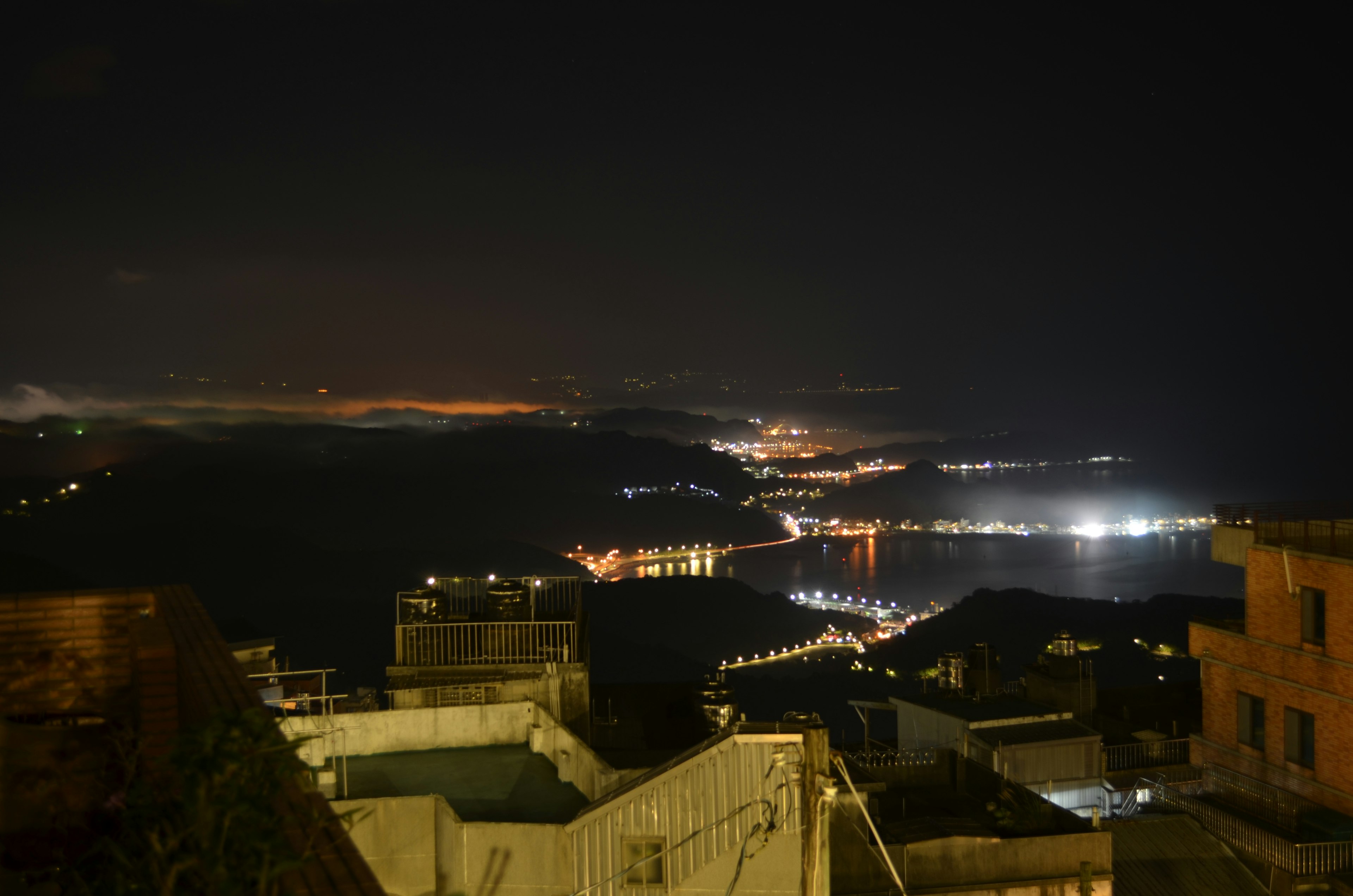 Pemandangan malam garis pantai dengan lampu kota