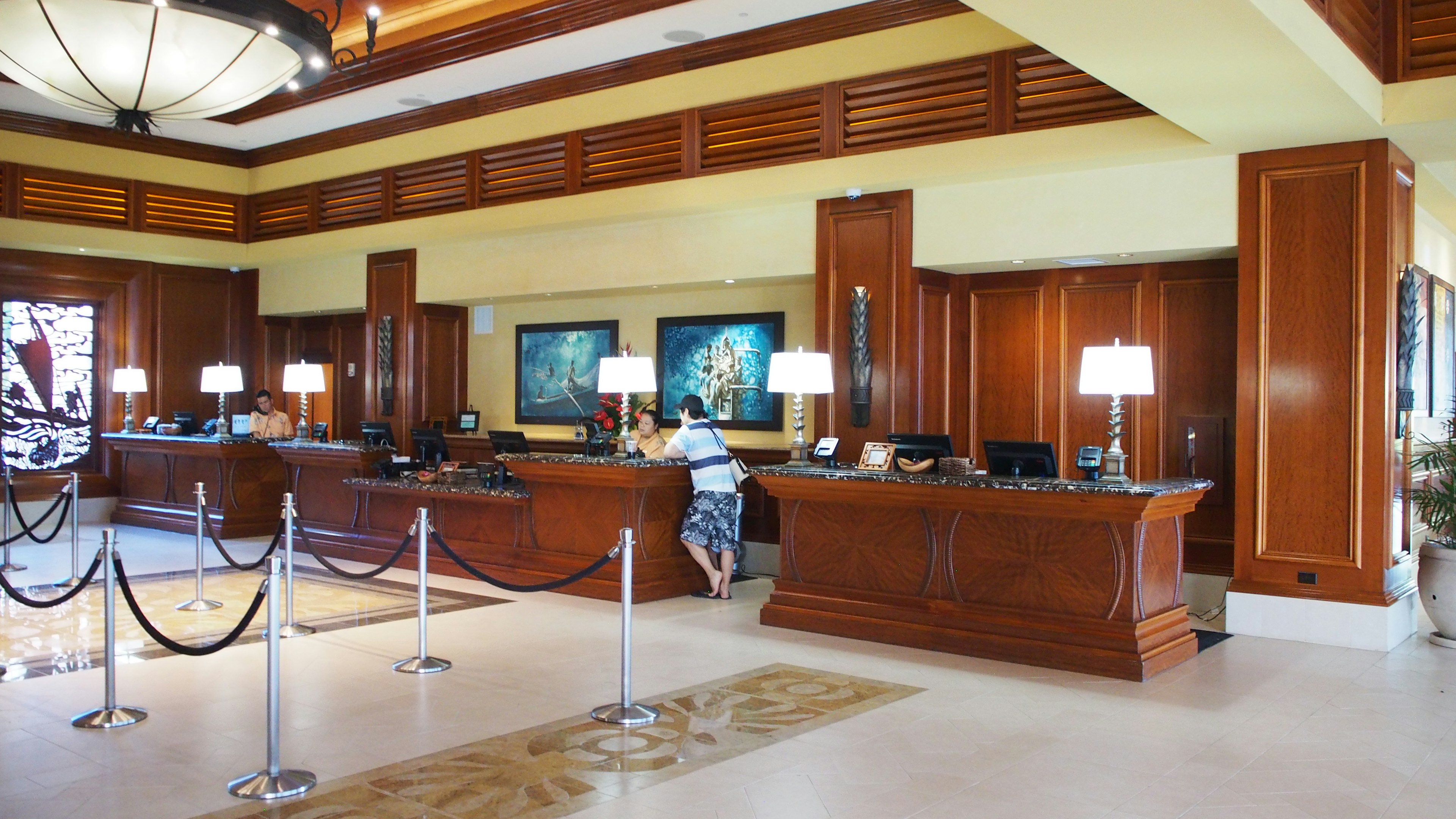 Bright hotel lobby with a reception desk and staff