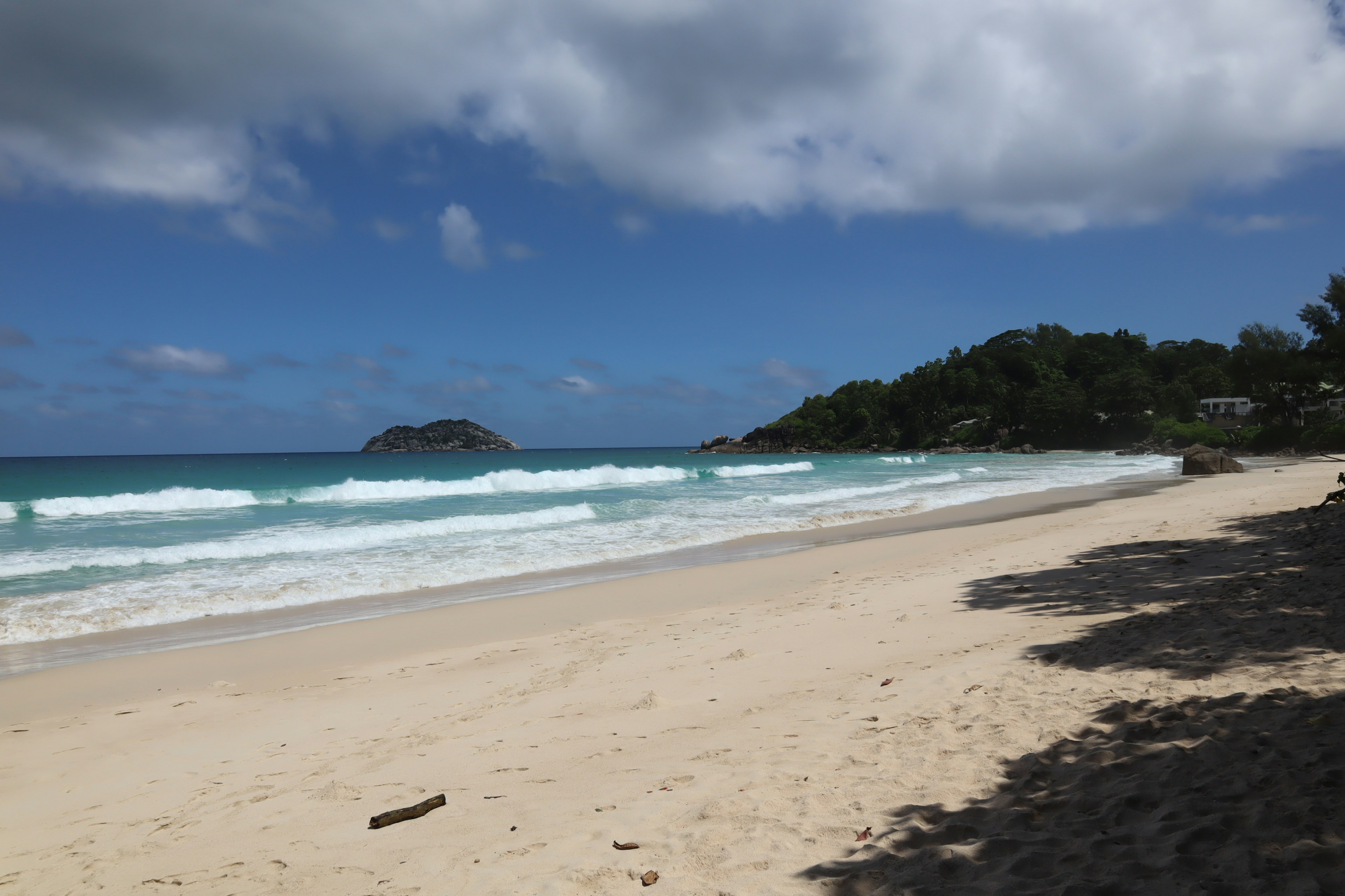 Schöne Strandlandschaft mit blauem Ozean und weißem Sand, Geräusch der Wellen, blauer Himmel und Wolken