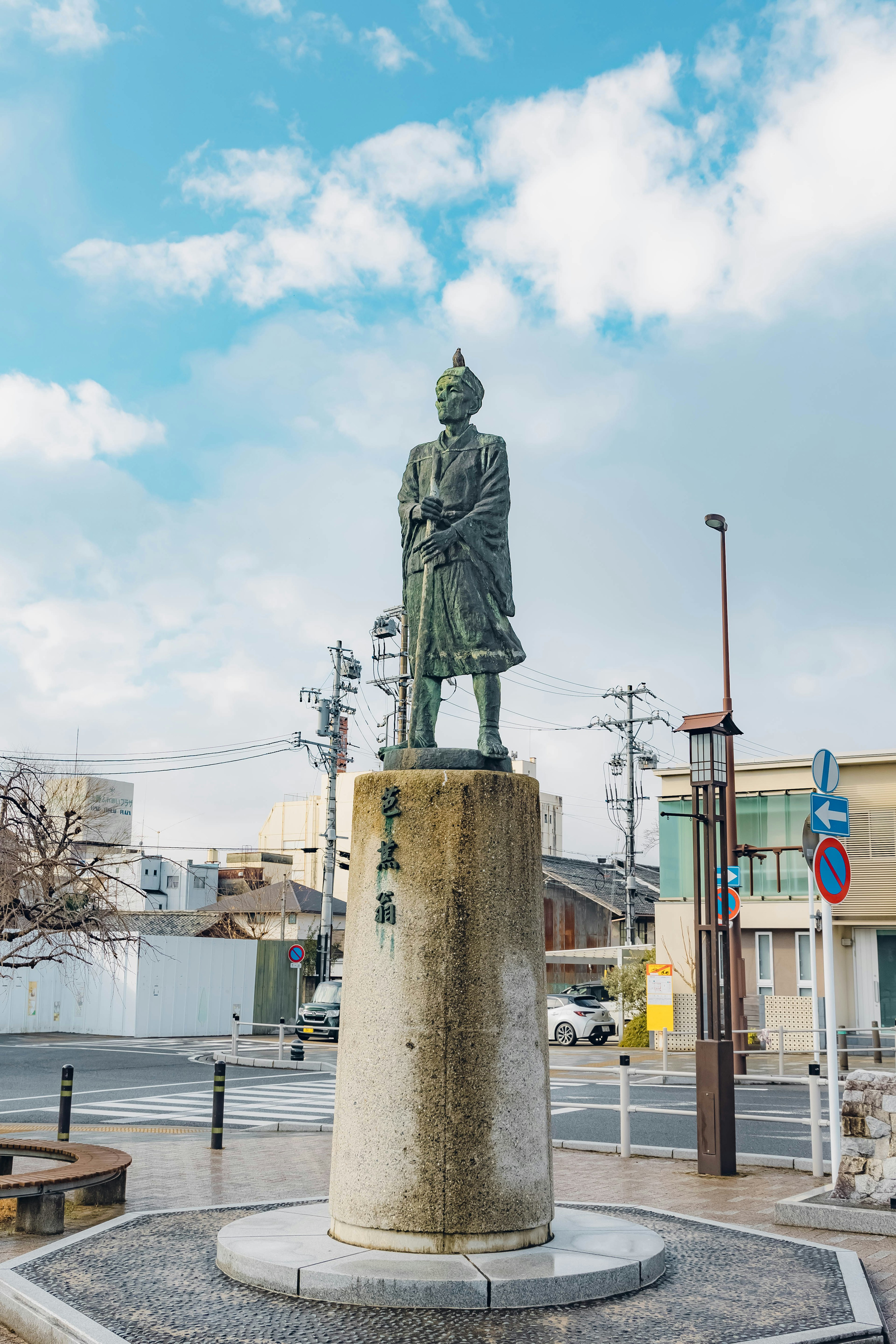 Bronze statue standing under a blue sky