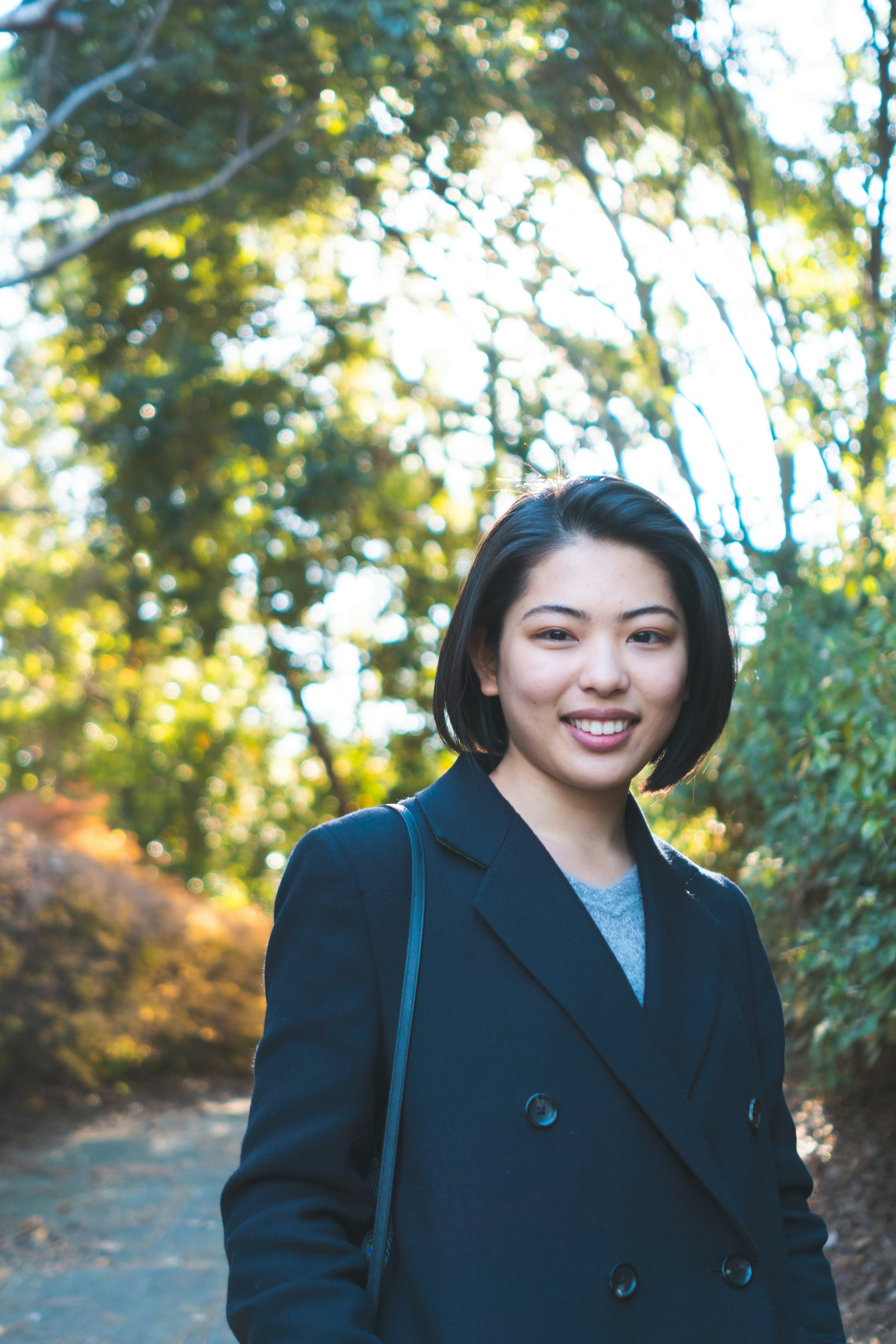 Portrait d'une femme souriante sur un chemin de parc verdoyant