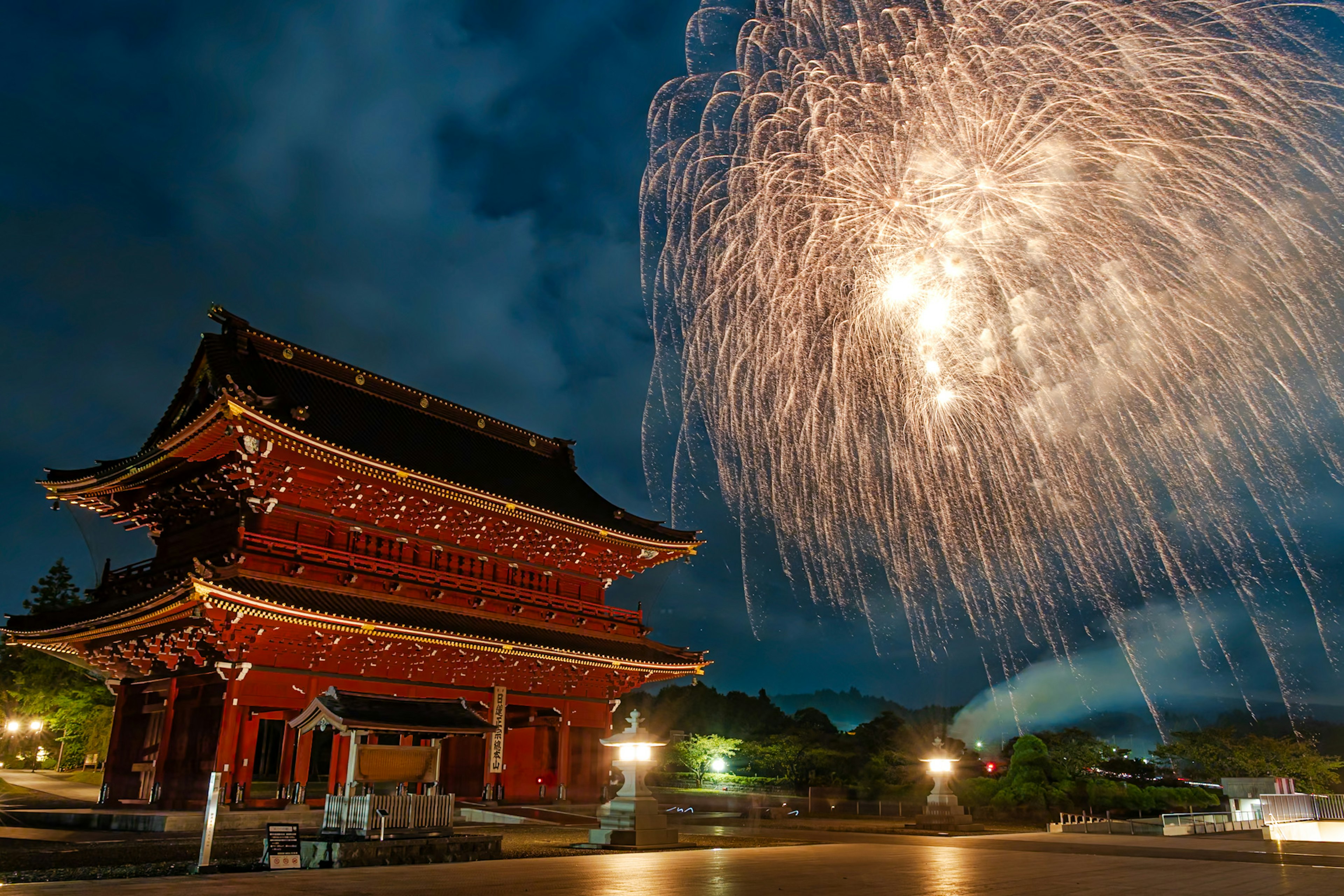 Edificio tradizionale rosso illuminato dai fuochi d'artificio nel cielo notturno