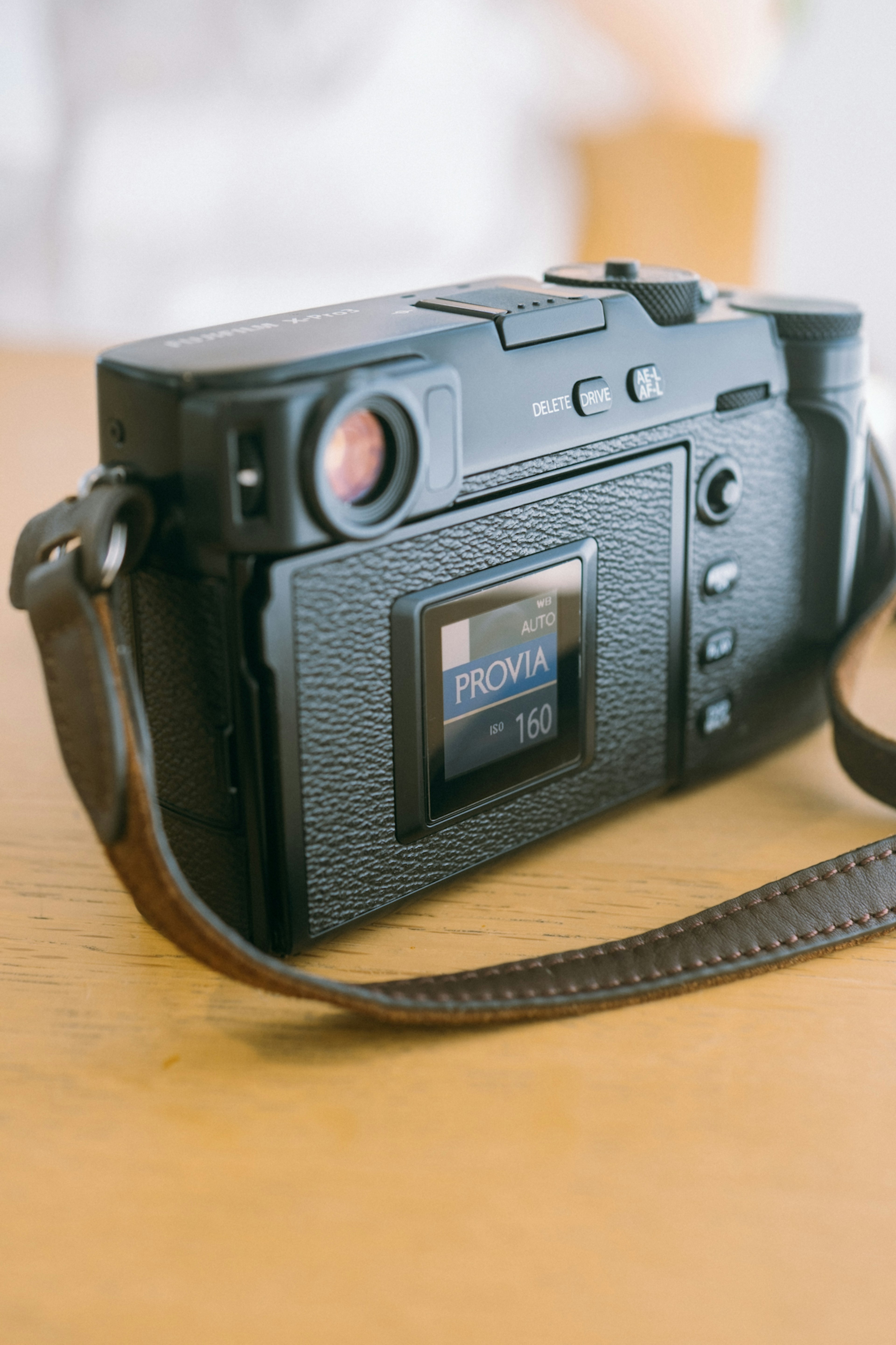 Close-up image of a camera featuring a black leather finish and strap