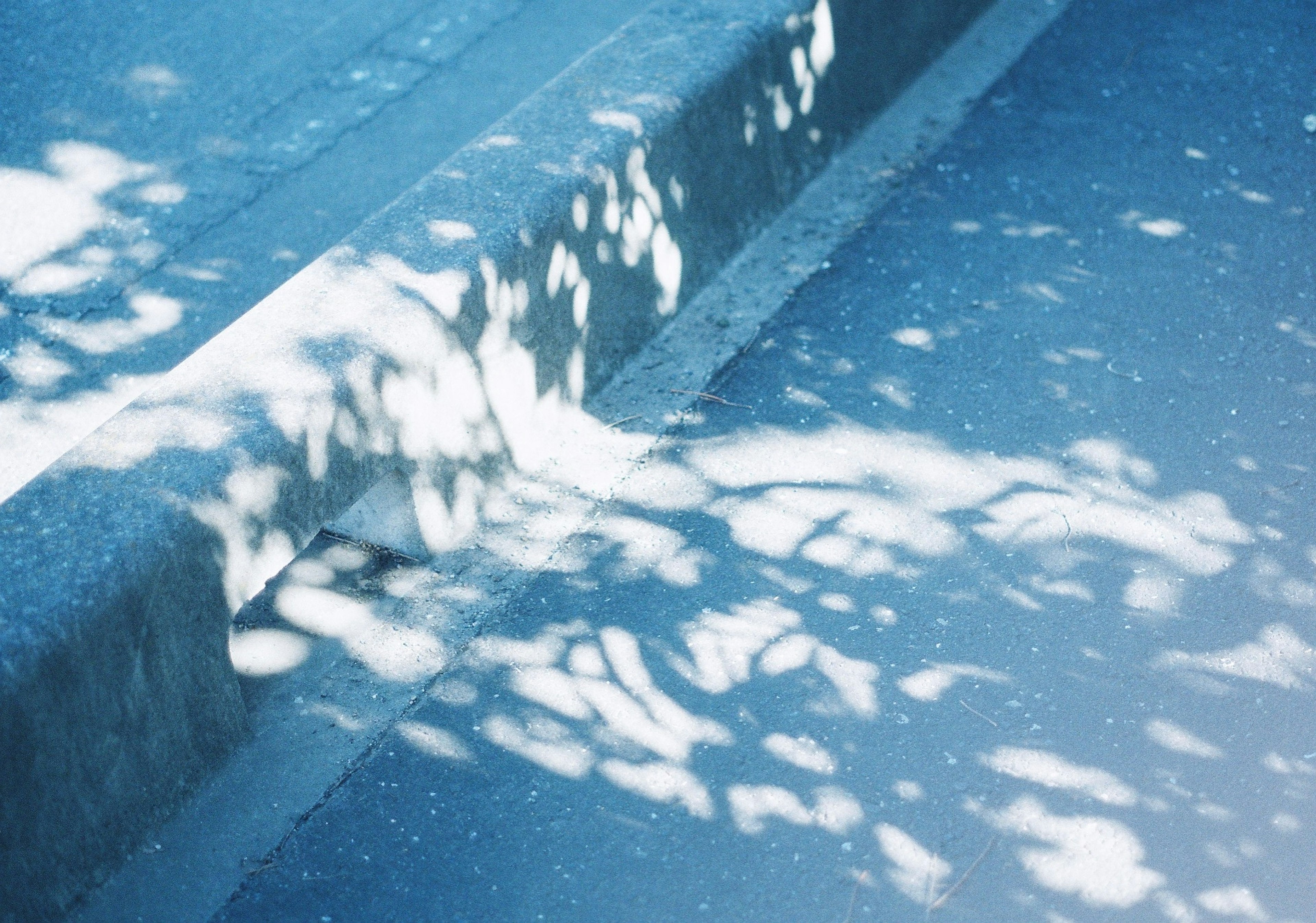 Borde de concreto con sombras y fondo azul