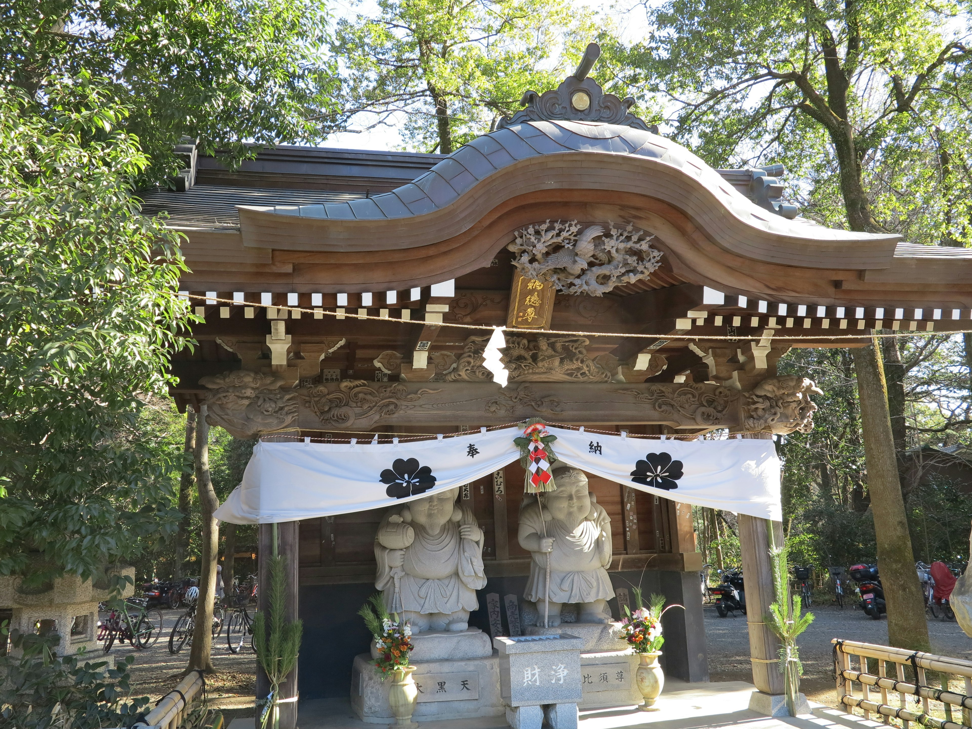 神社の伝統的な建築様式と石像が特徴的な風景