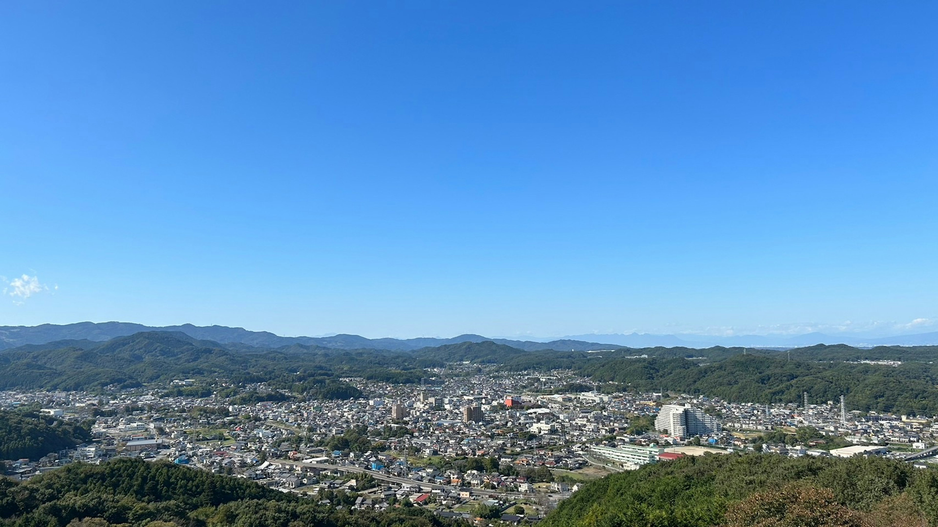 Panoramic view of a town surrounded by mountains and clear blue sky