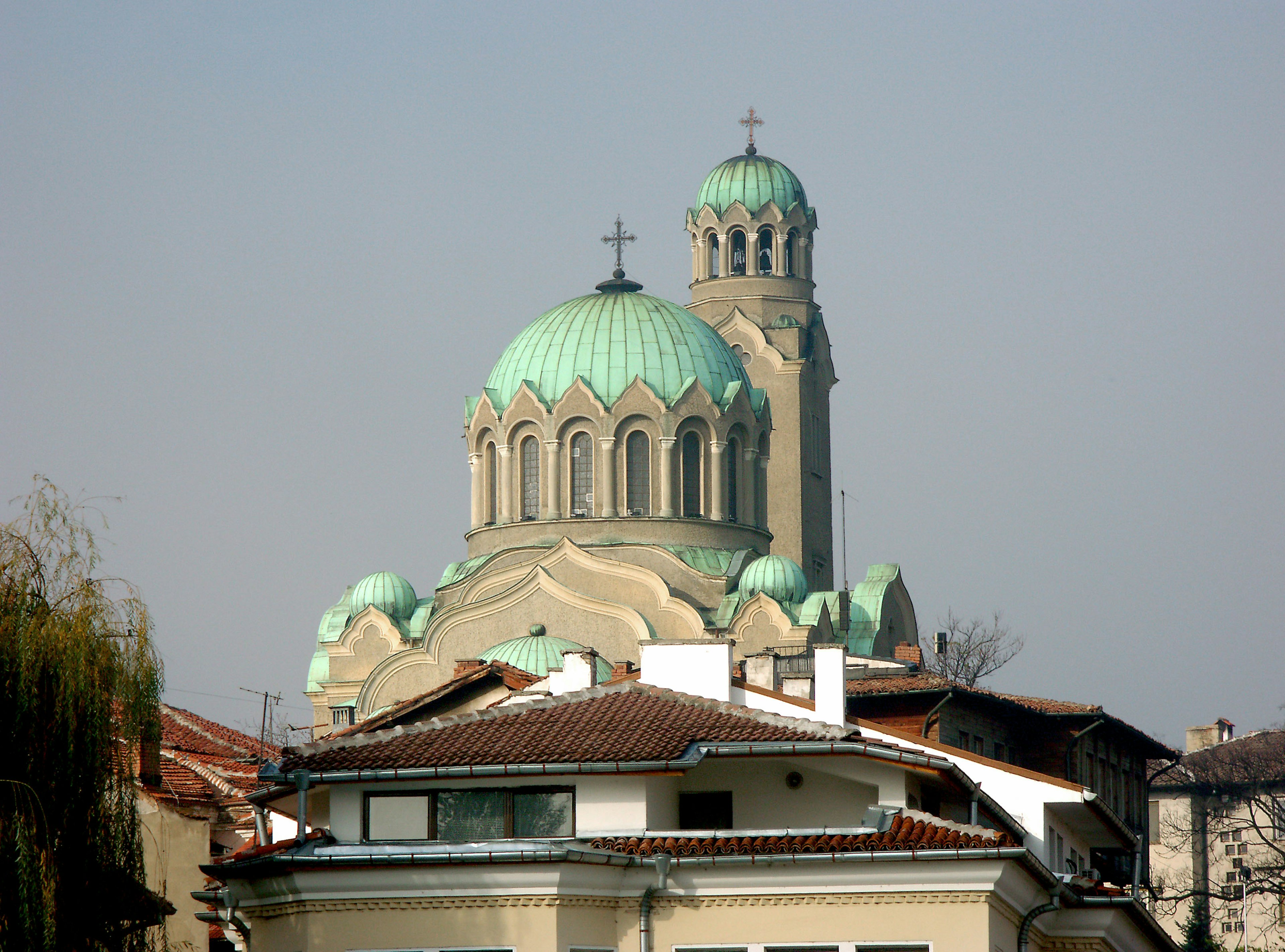 Church with green domes and surrounding buildings