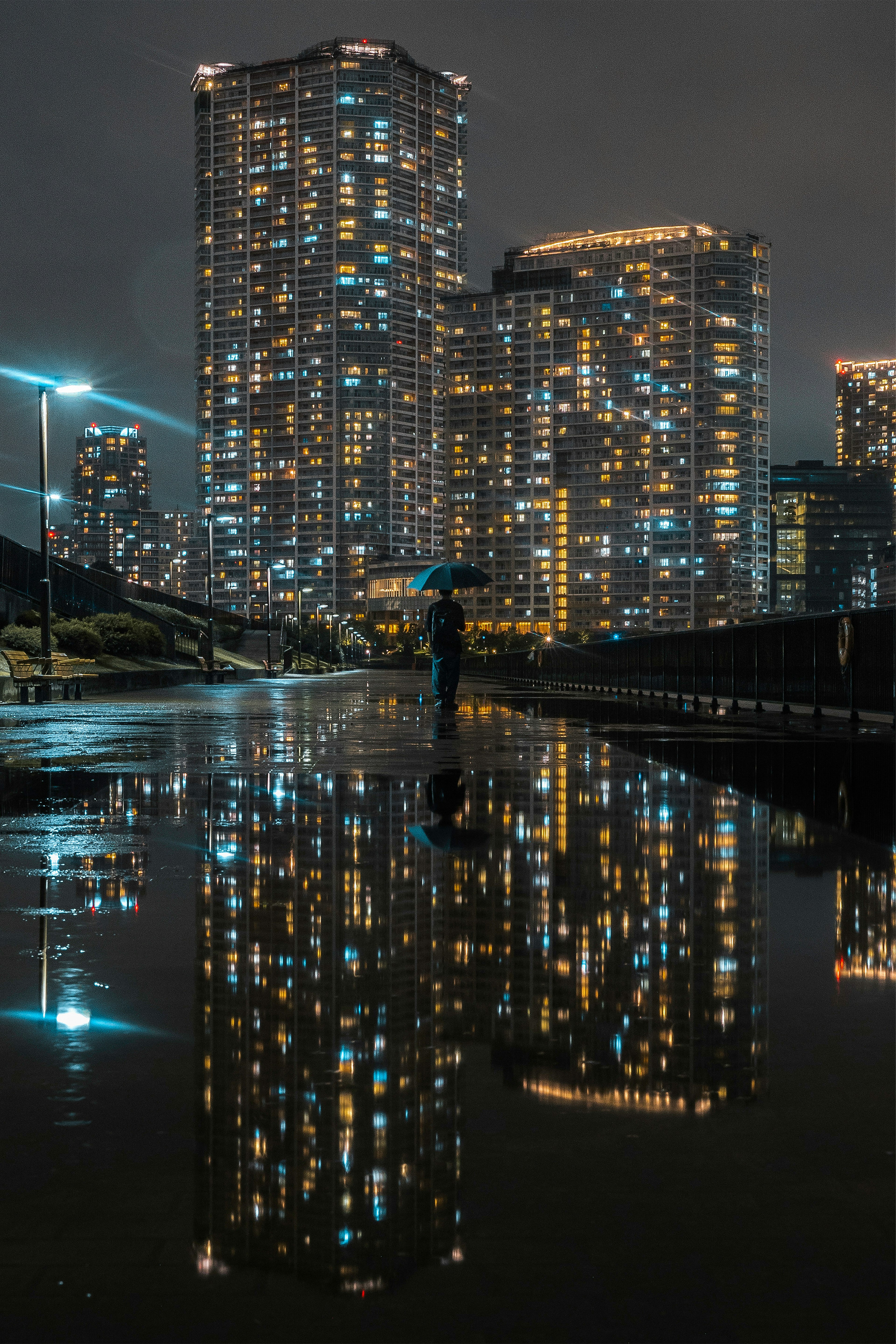 Nighttime city skyline with high-rise buildings reflecting in water