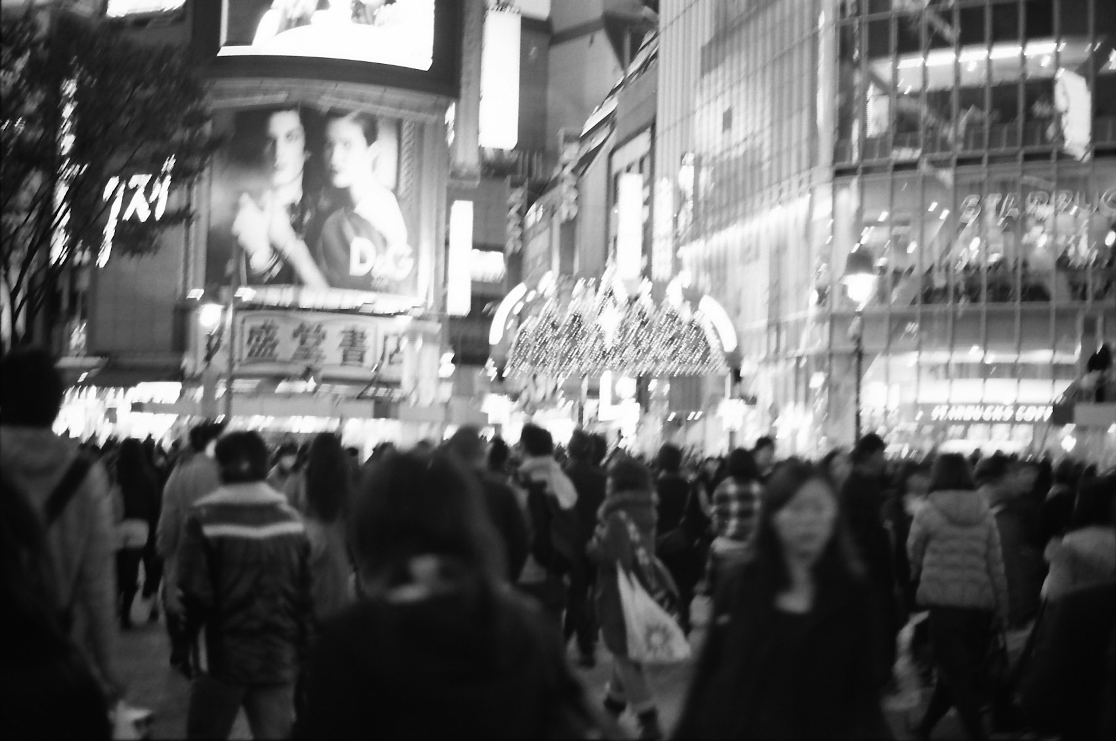 東京の渋谷交差点の賑やかな夜の風景に人々が集まっているモノクロの写真