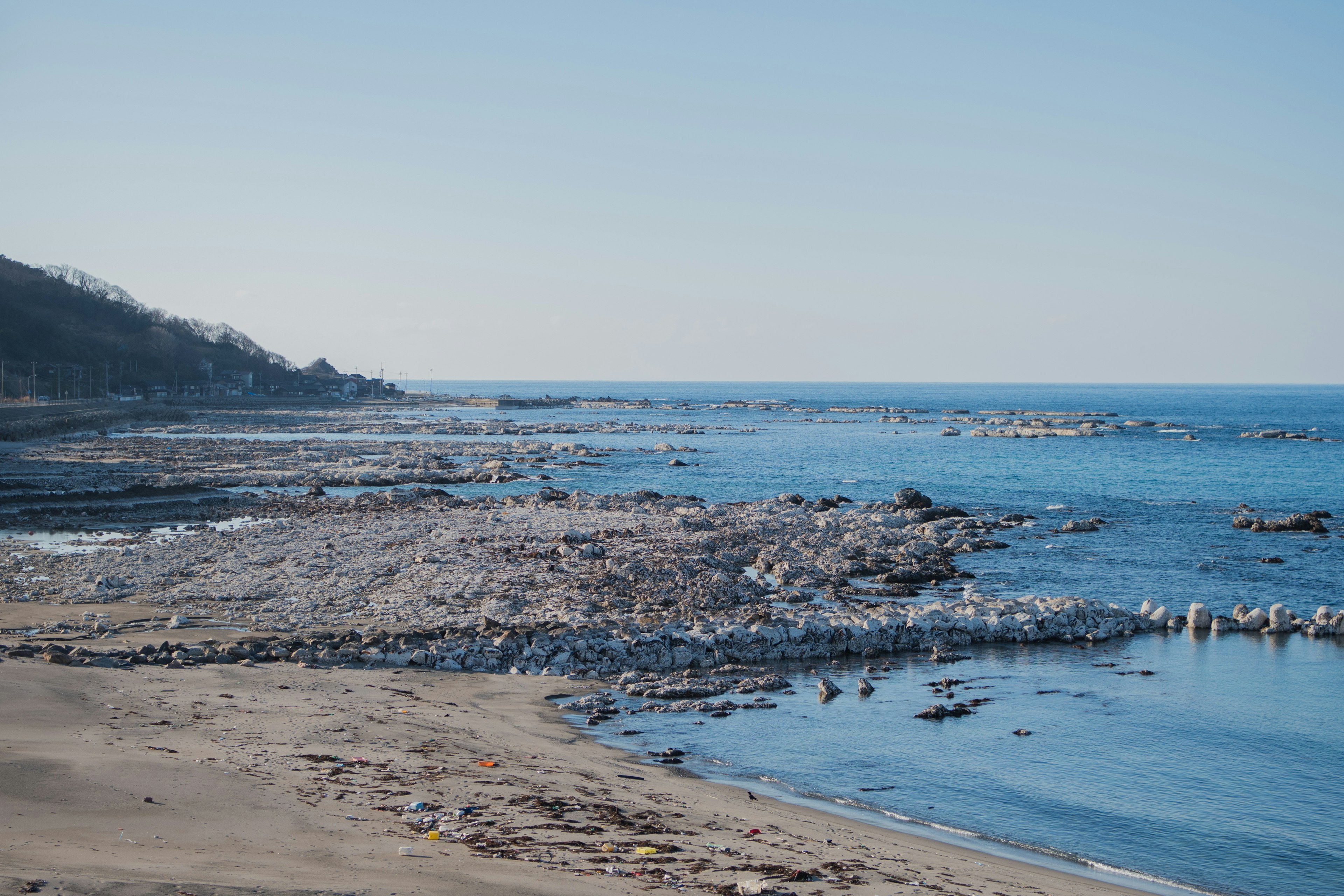 Coastal landscape with blue sky rocky shoreline and calm sea