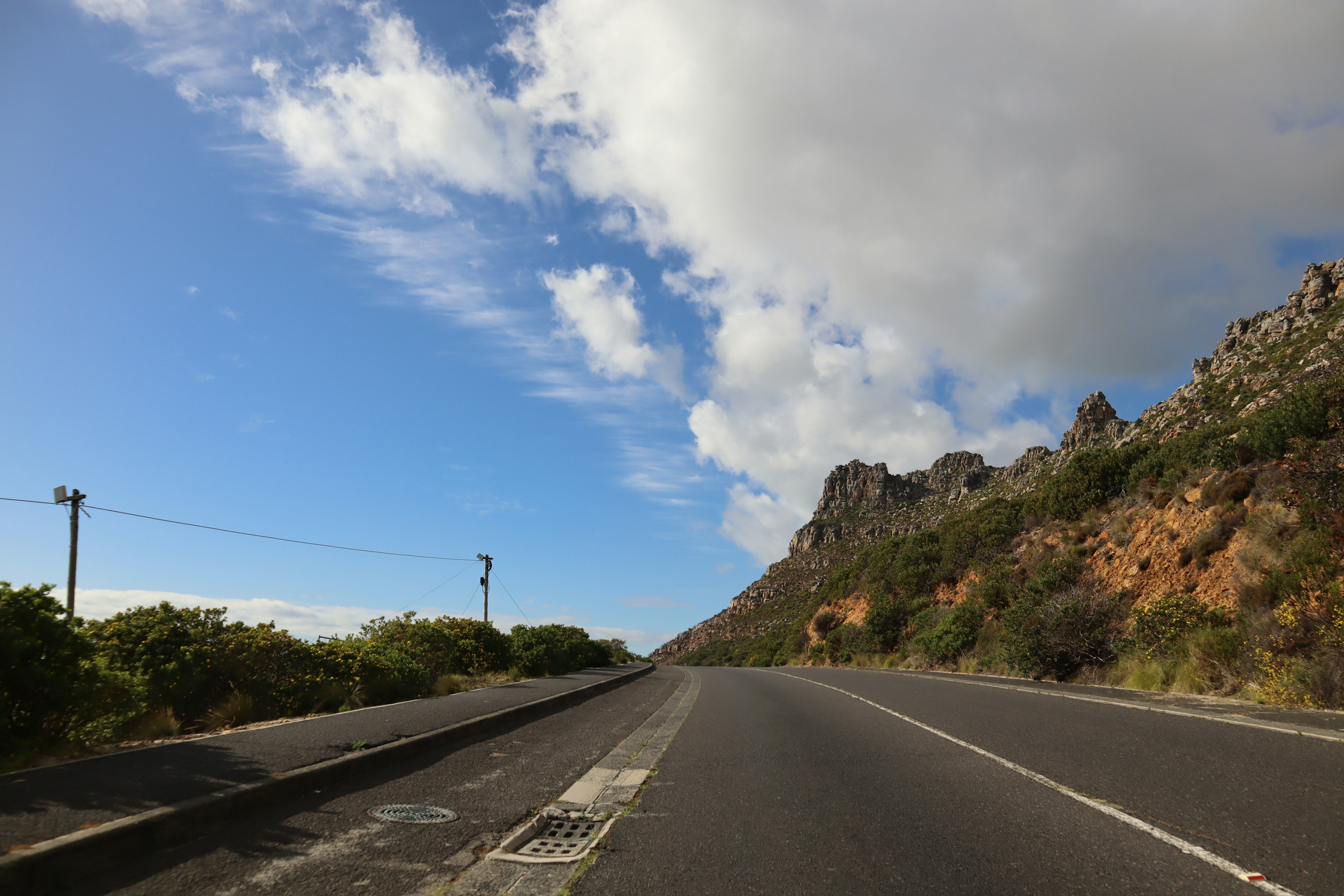 Route de montagne pittoresque avec ciel bleu et nuages