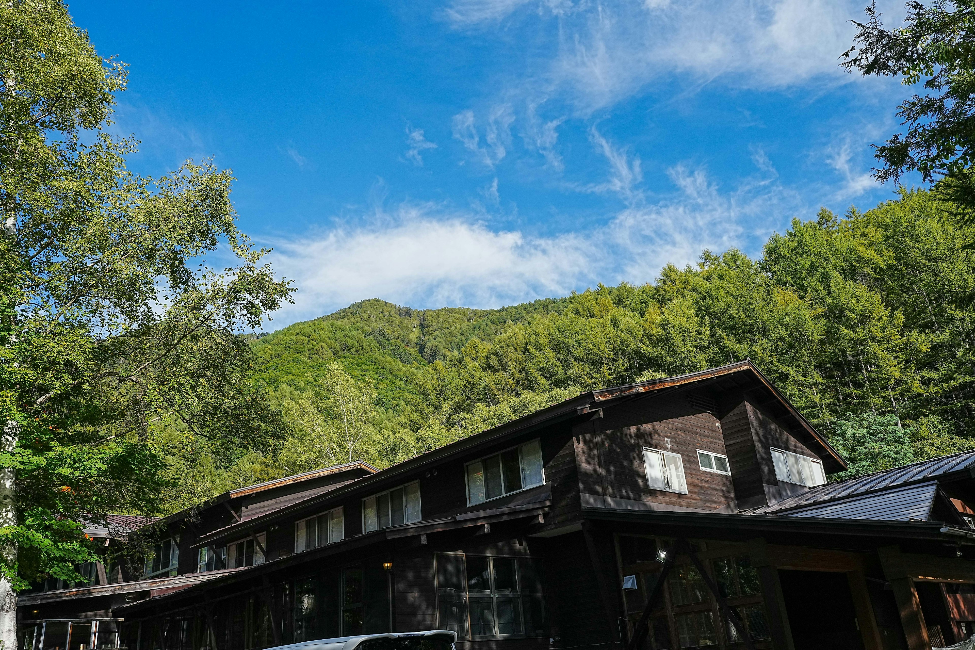 Alojamiento de madera rodeado de montañas verdes