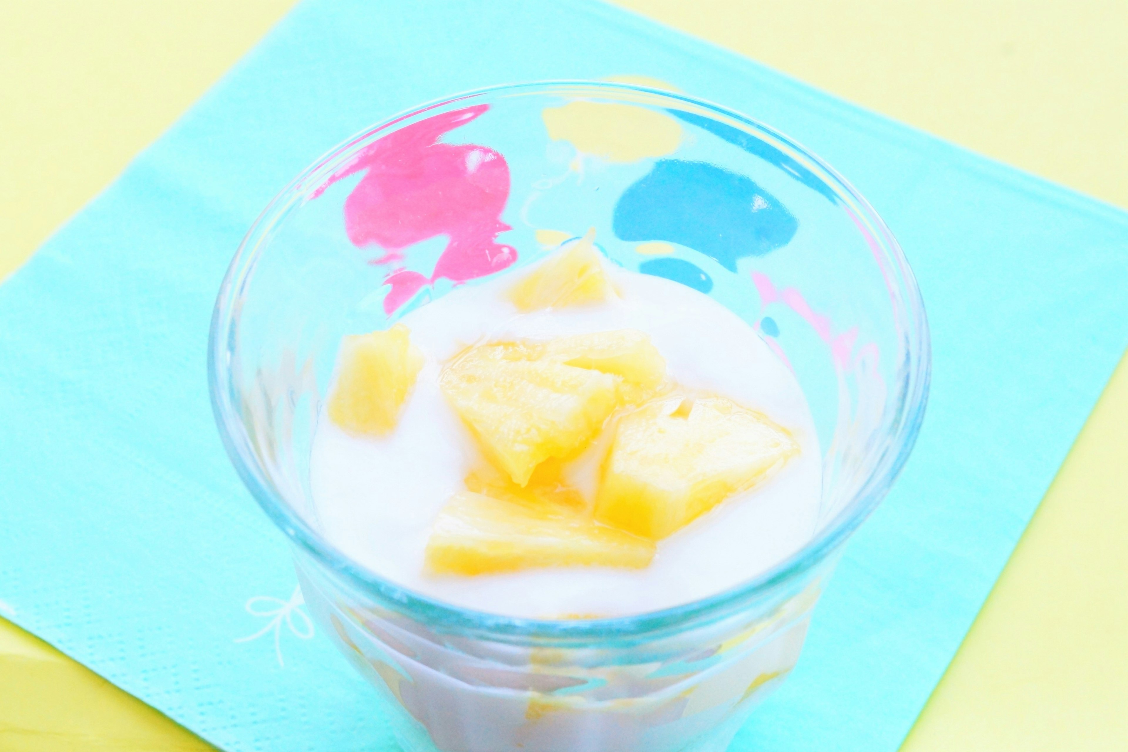 Yogur con trozos de piña en una taza colorida