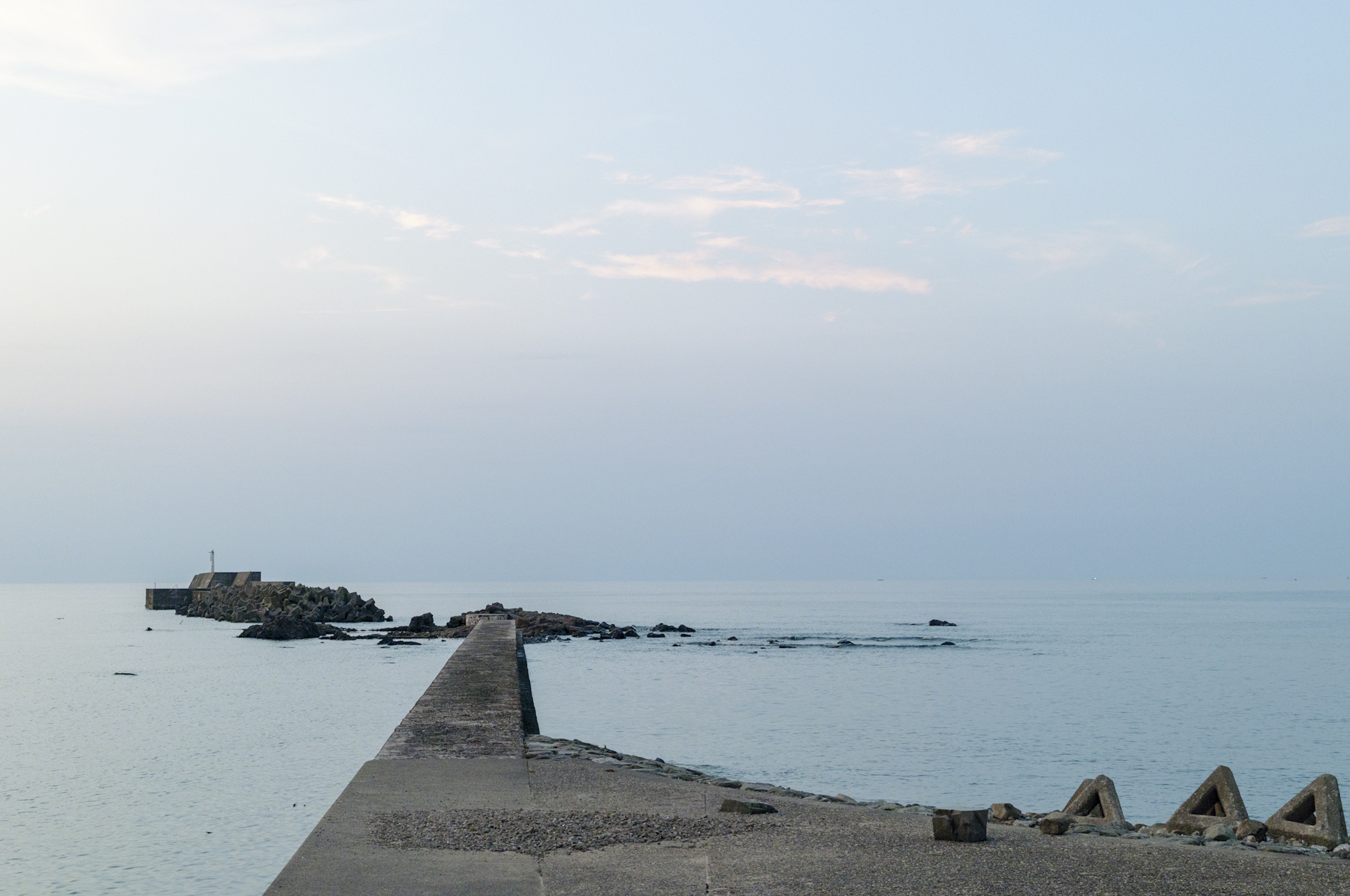 Paesaggio marino sereno con un molo sotto un cielo nebbioso