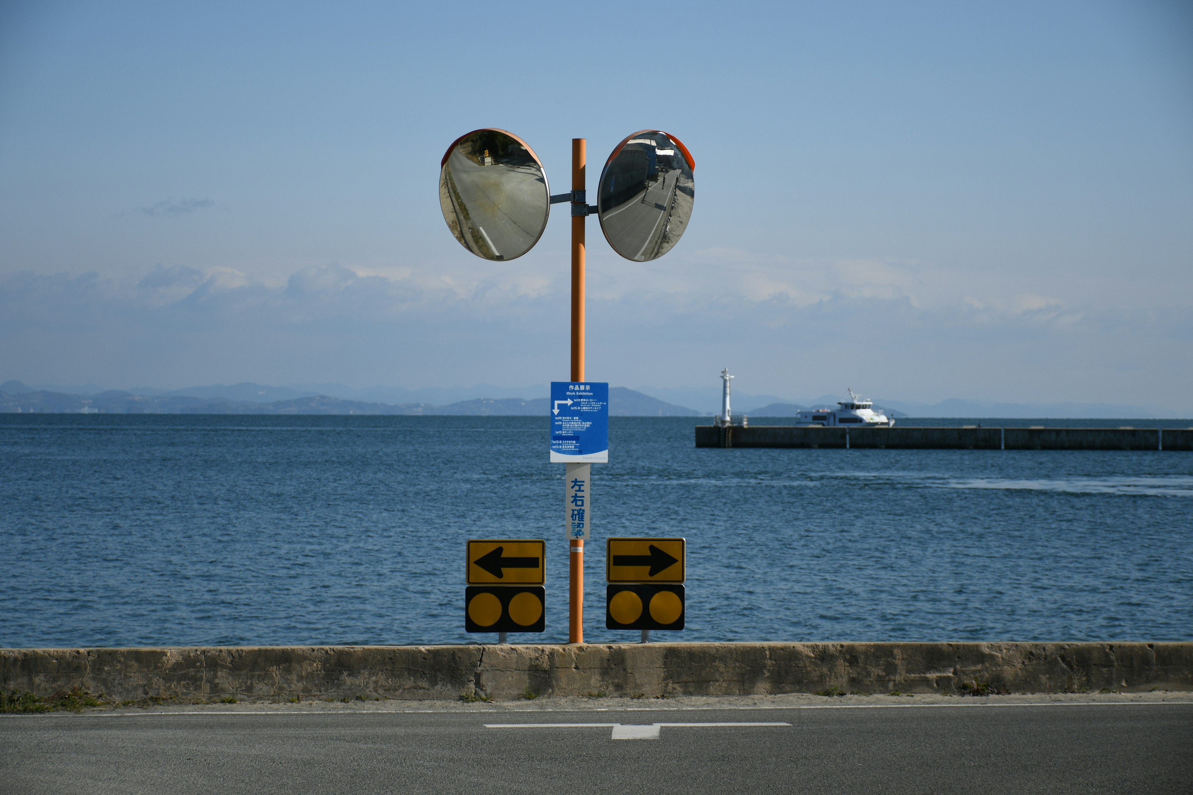 Panneaux de signalisation et miroirs surplombant la mer et le port